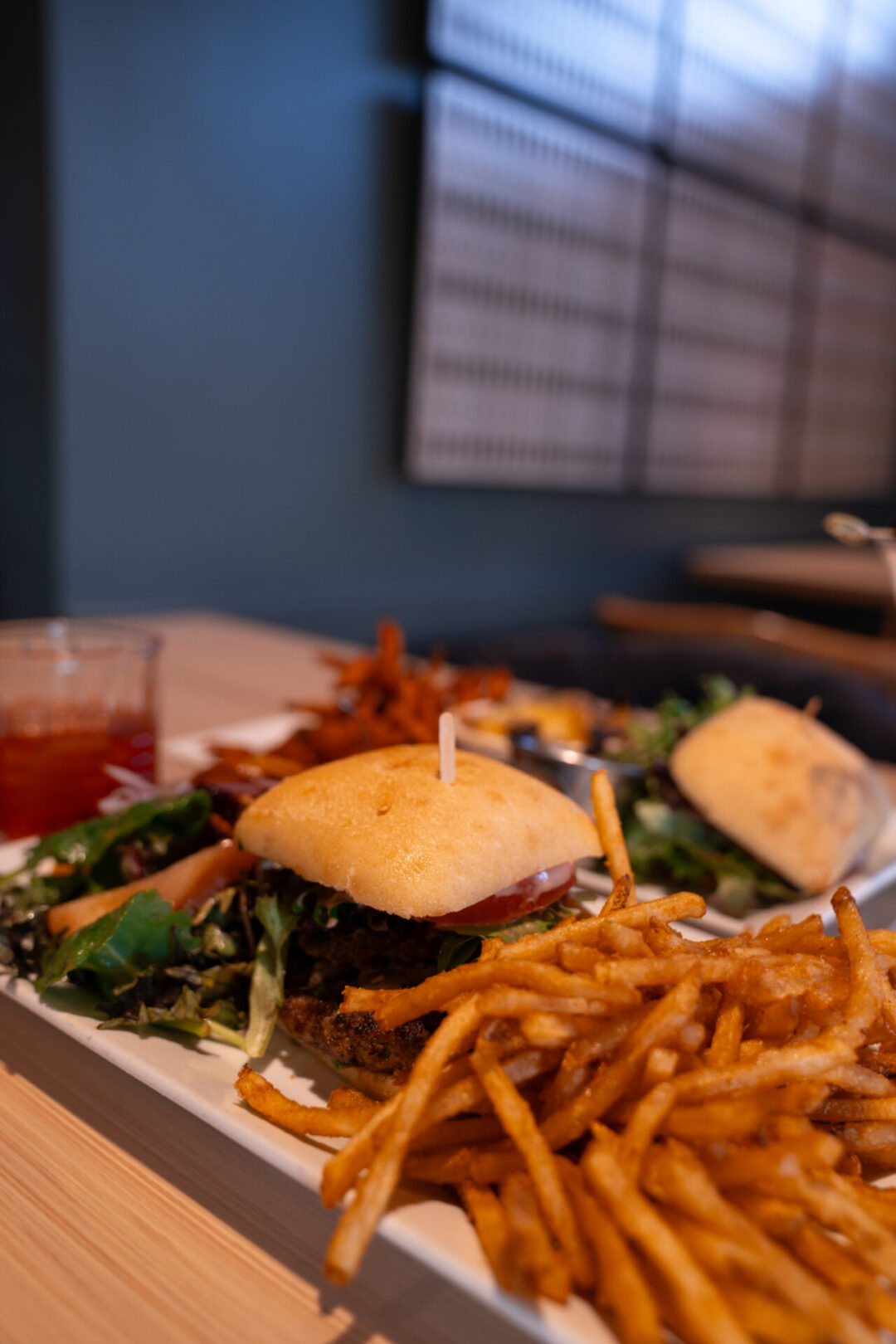 Two plates with burgers, salads and fries from TASTE