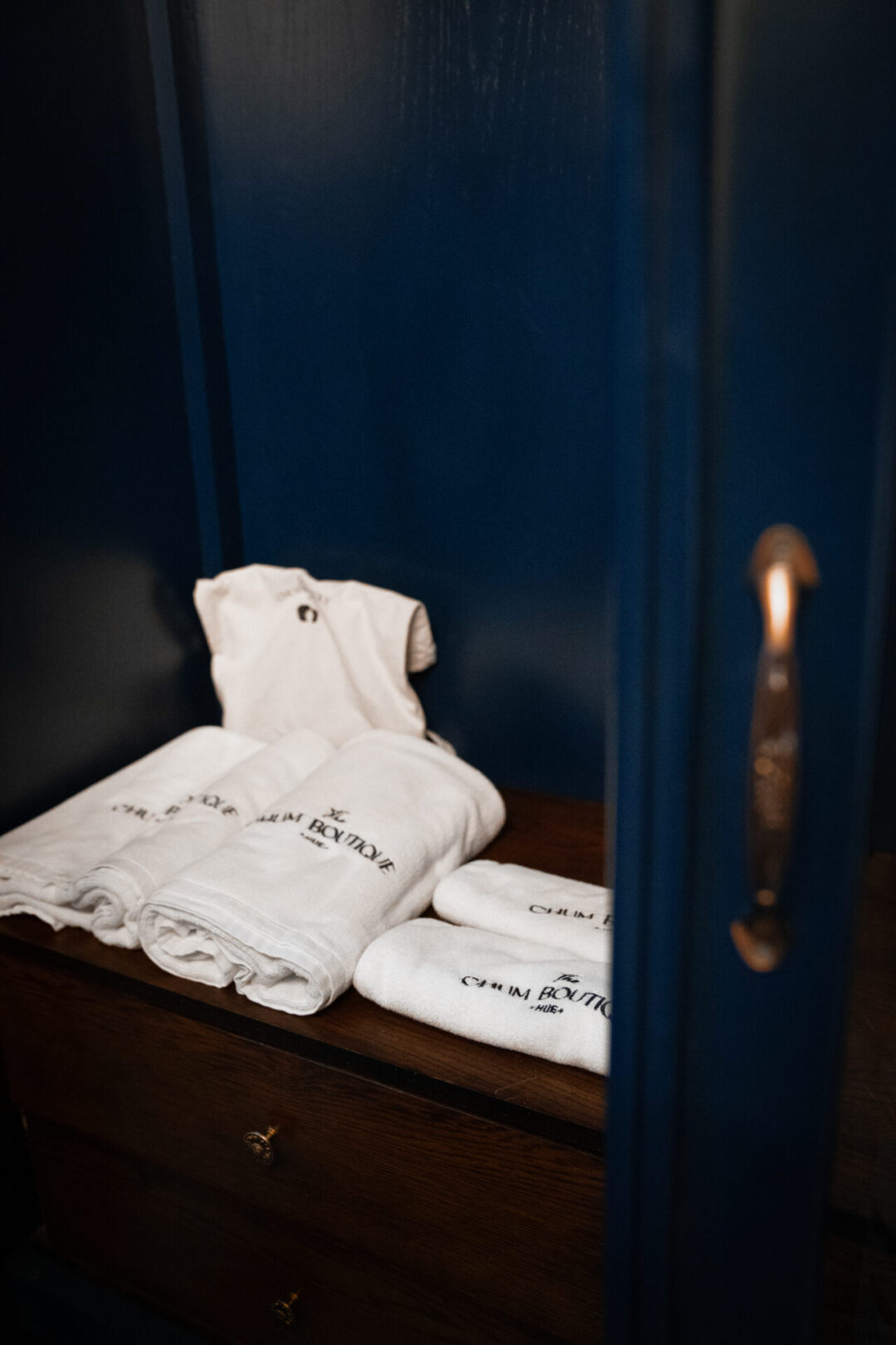 A set of "Chum Boutique" branded bath towels inside a blue armoire in Hue, Vietnam
