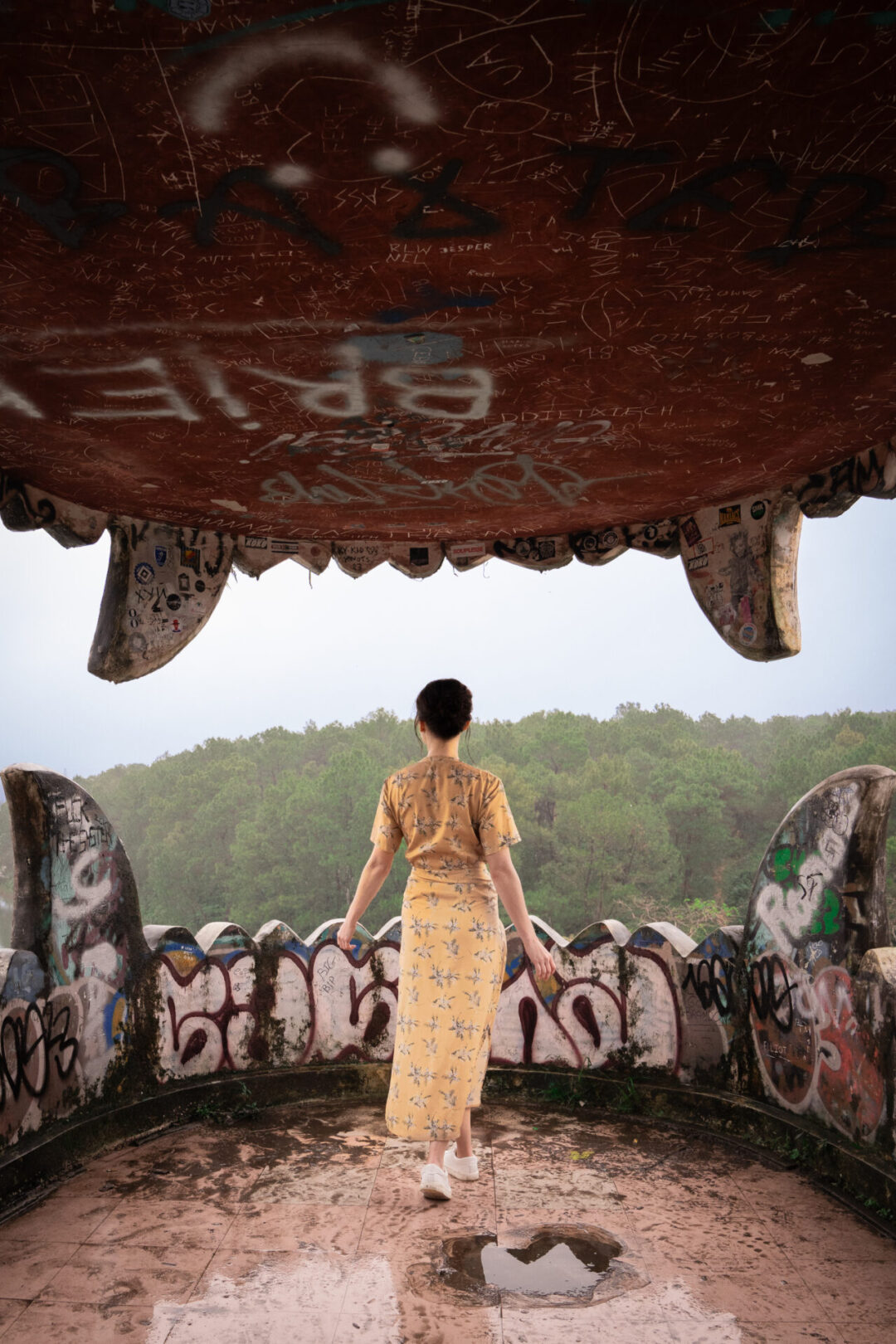 Travel Blogger Jordan Gassner looking out from inside the mouth of the dragon structure in Hue, Vietnam