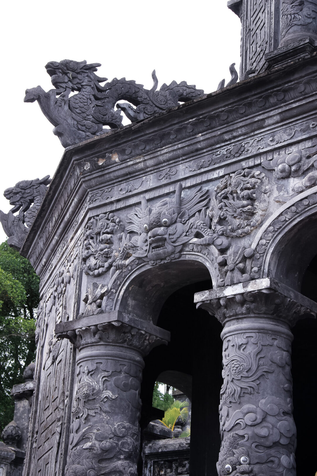 The up way to the Tomb of Khai Dinh in Hue, Vietnam leads through beautifully intricate sculptures by stairs that are surrounded by large stone dragons.