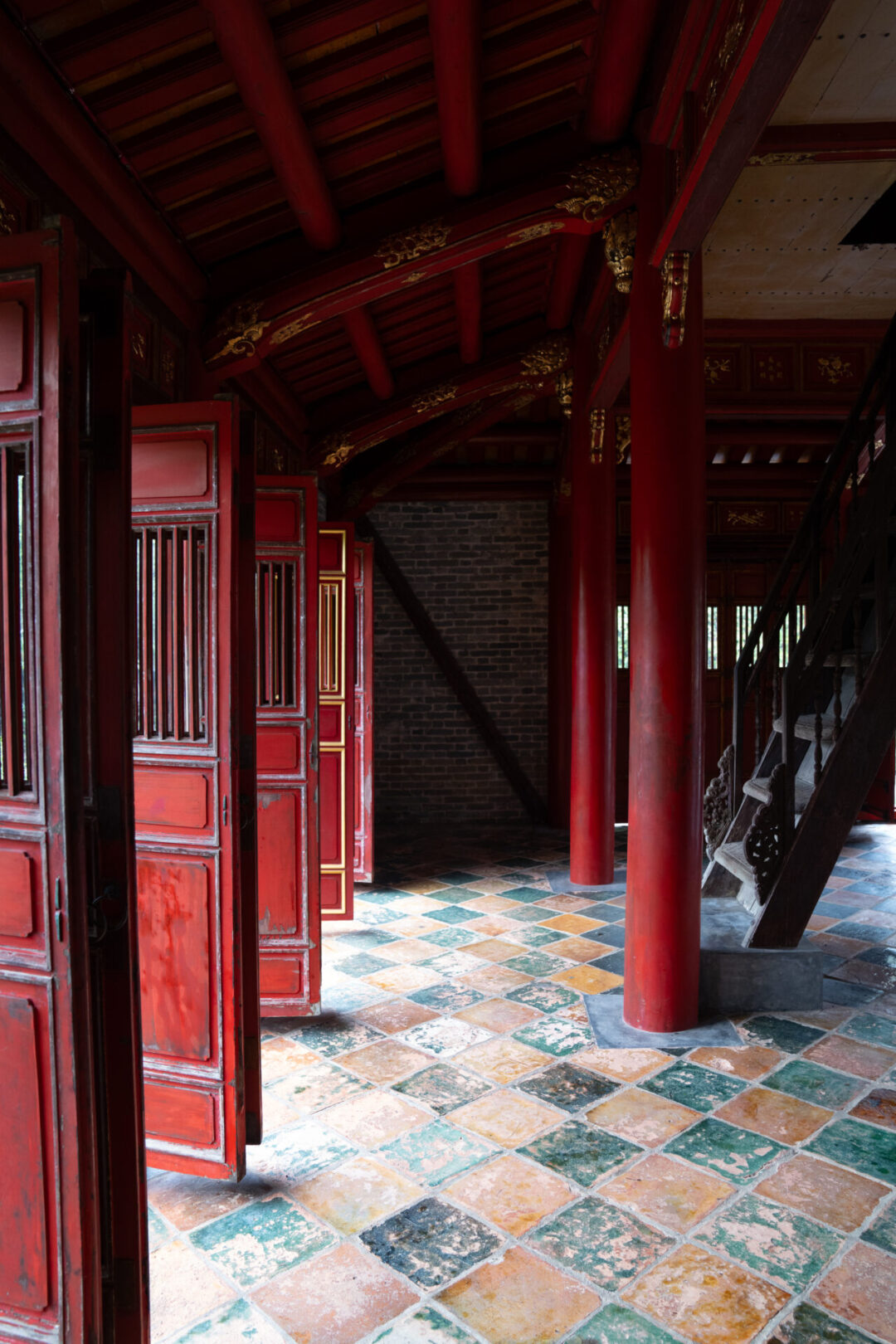 The interior of a building with red doors and columns at the Tomb of Minh Mang in Hue, Vietnam