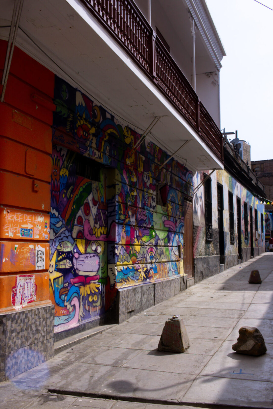 a collage of cartoon character graffiti set on an orange building in Callao in Peru