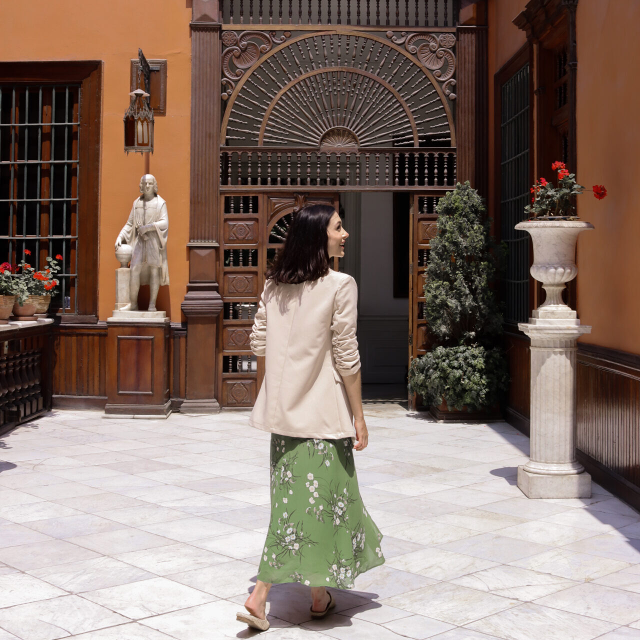 Travel Blogger Jordan Gassner walking intothe house from the porch  of Casa Aliaga in Lima, Peru