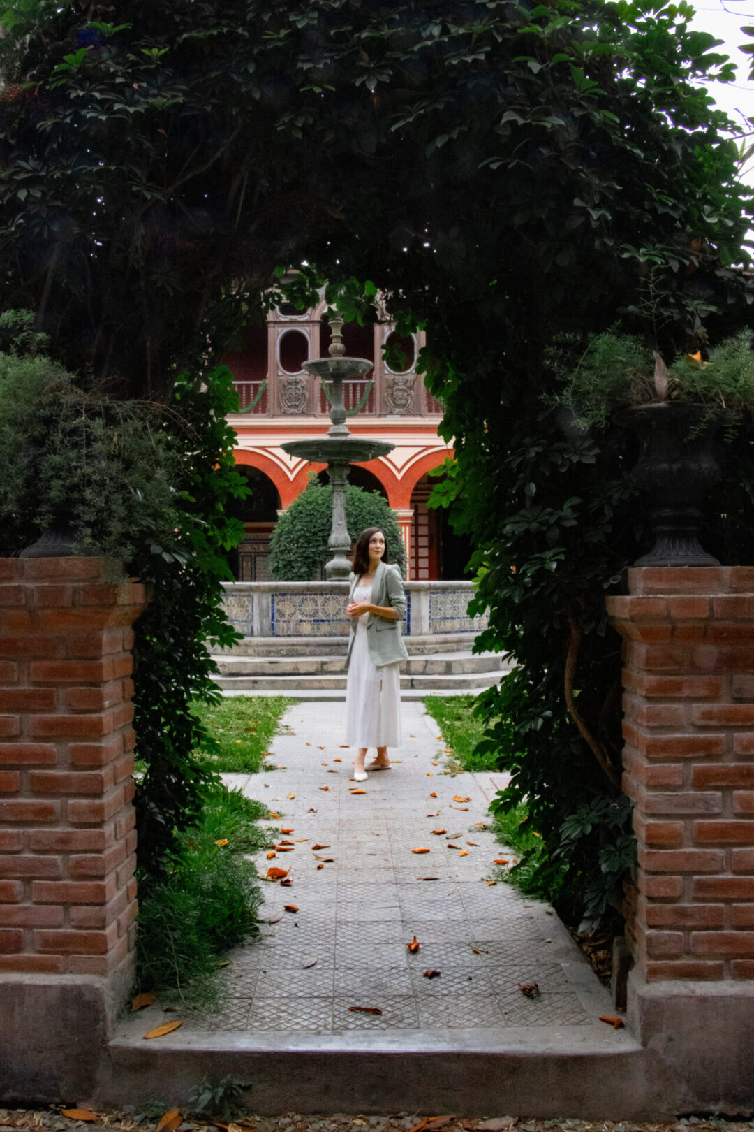Travel Blogger Jordan Gassner standing along an ivy-covered path in the courtyard at Santo Domingo Convent in Lima, Peru