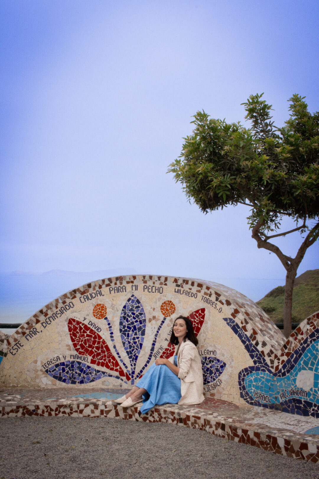 Travel Blogger Jordan Gassner smiling while sitting down and enjoying the scenery at Parque el Amor along the coast of Lima, Peru