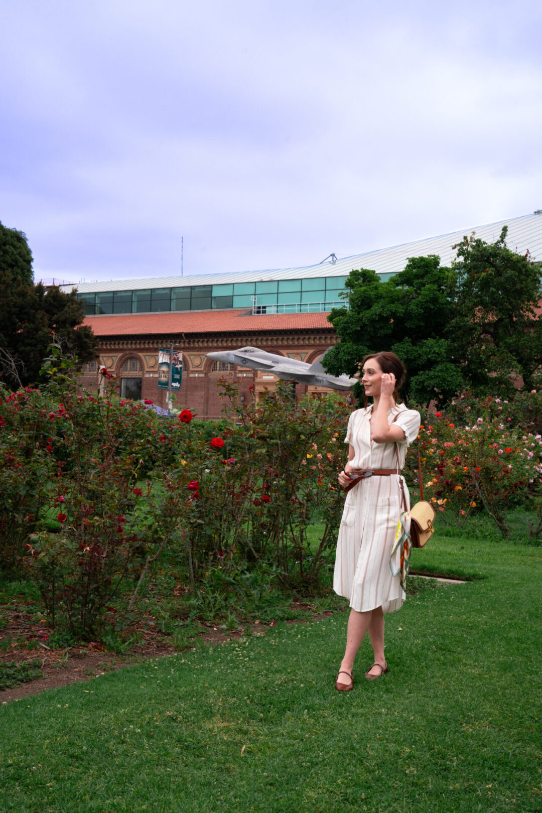 Travel Blogger Jordan Gassner standing and smiling in front of a fighter jet figurine at the California Science Center