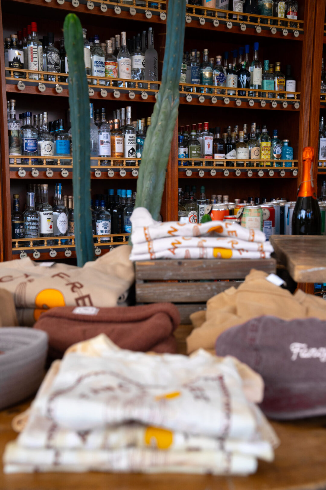 A table of merch in front of shelves of high-end liquors inside Fancy Free Liquor in Burbank. California