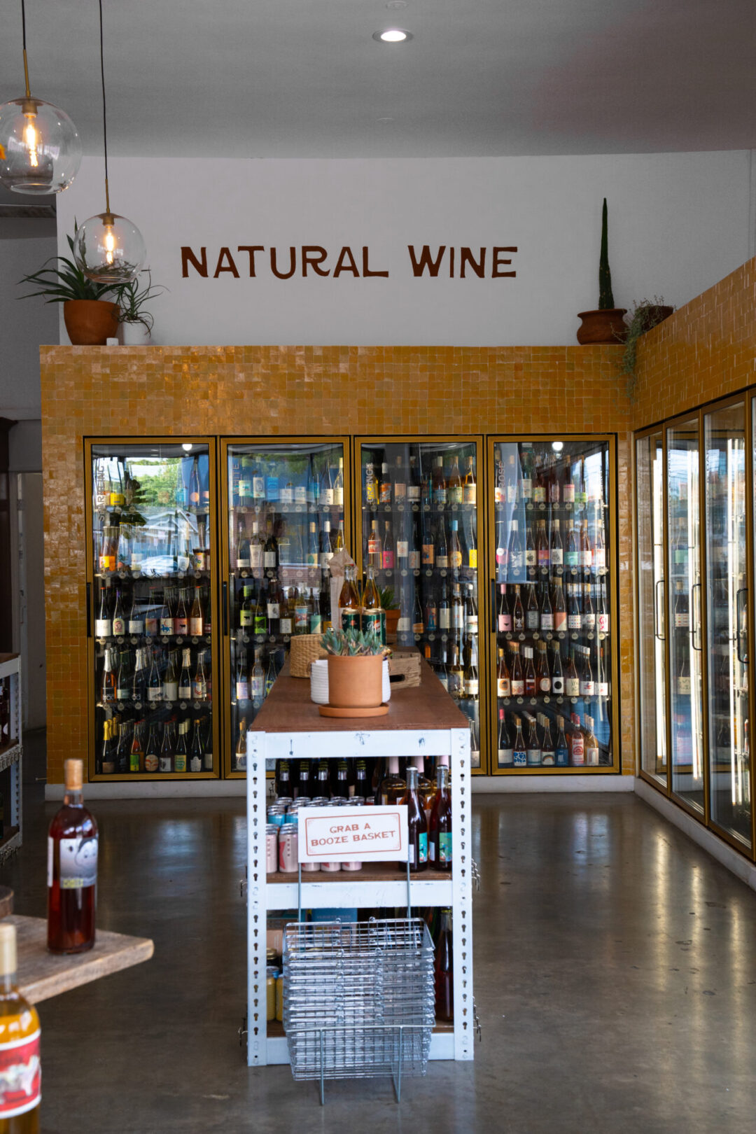 A row of fully-stocked natural wine fridges inside Fancy Free Liquor in Burbank, California