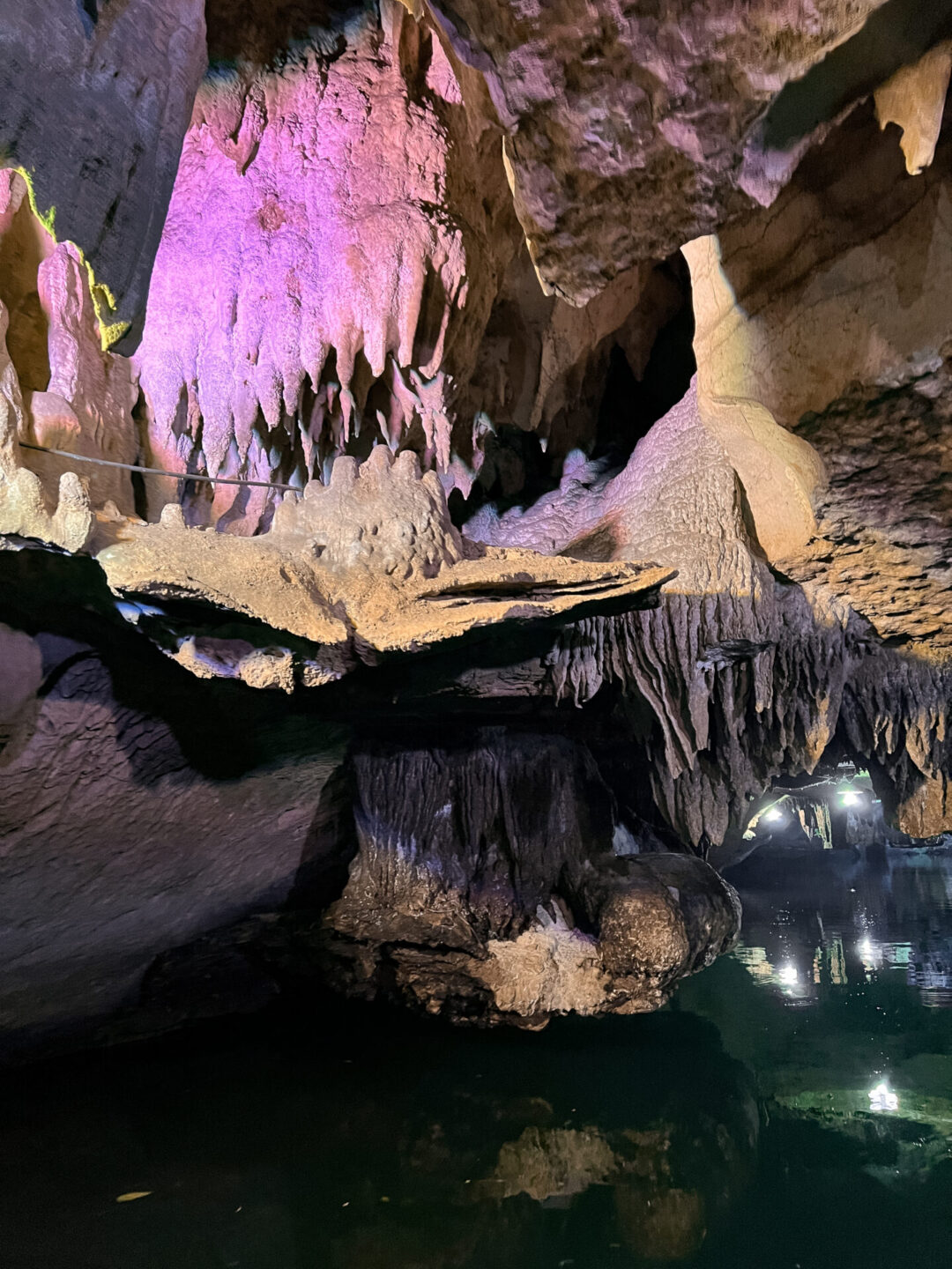 Purple and orange lights illuminating the stalactites inside a cave at Trang An Landscape Complex in Ninh Binh, Vietnam
