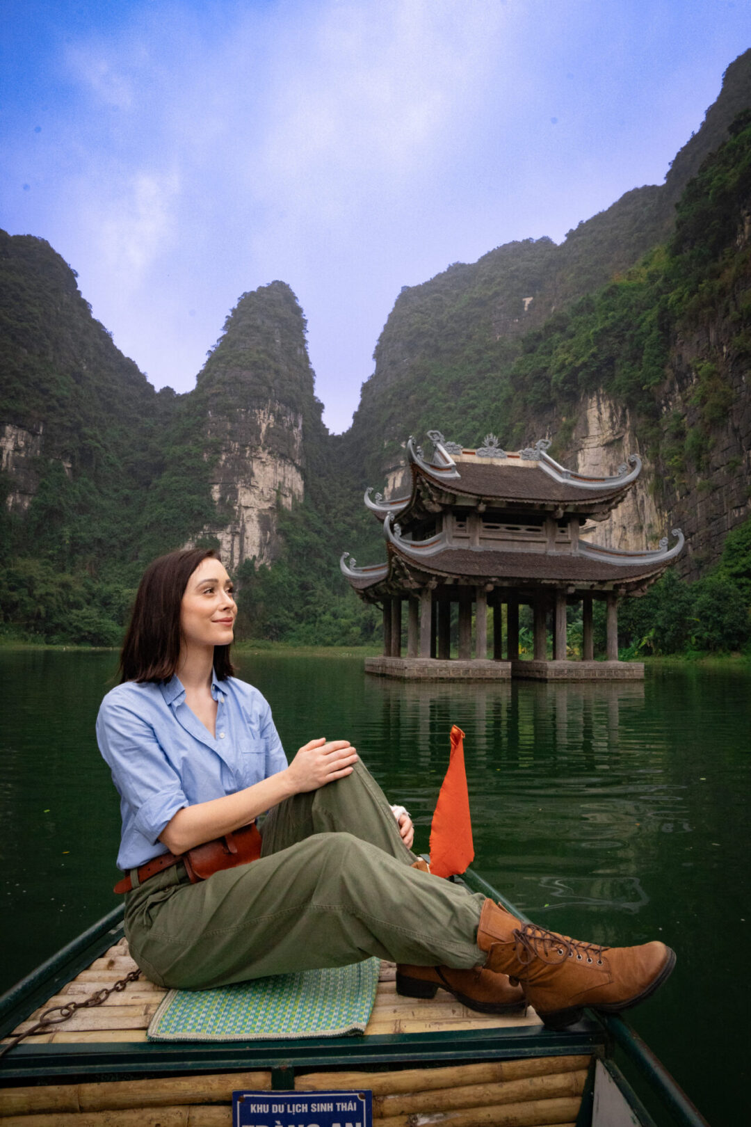 Travel Blogger Jordan Gassner floating near a double-roofed water pagoda by Vu Lam Palace from a traditional sampan boat in Trang An Landscape Complex in Ninh Binh, Vietnam