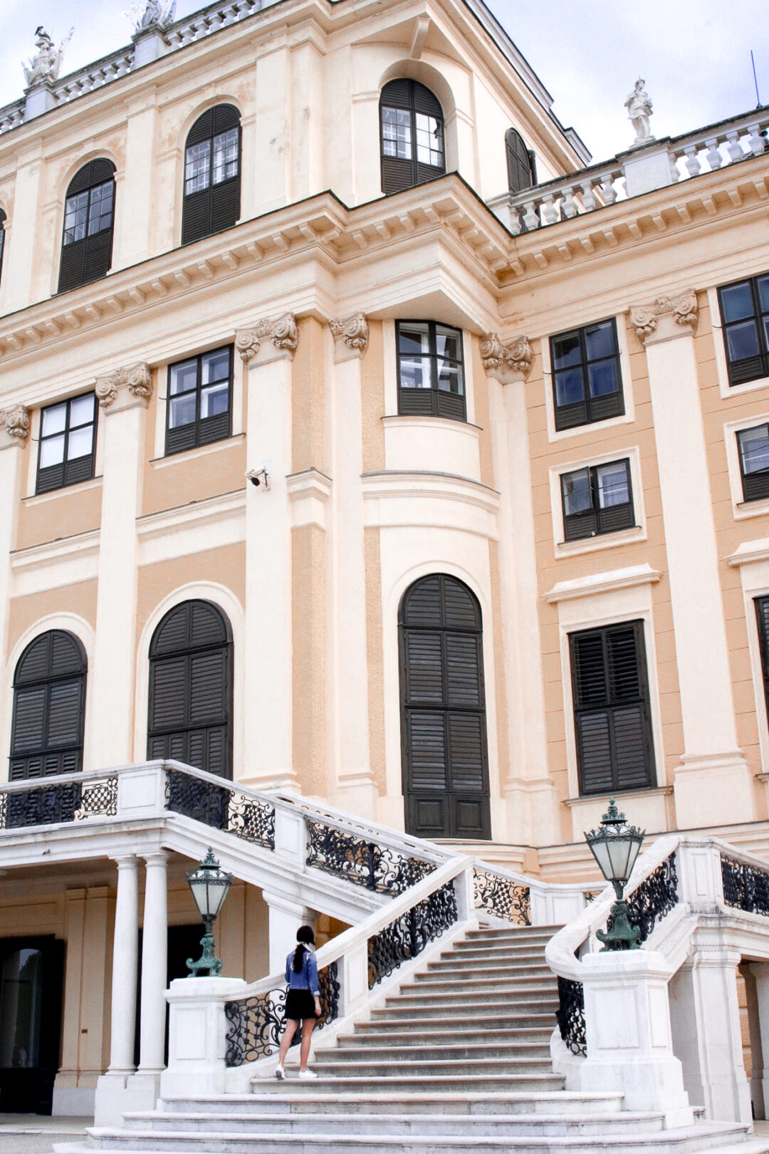 Travel Blogger Jordan Gassner climbing up the stairs of Schönbrunn Palace in Vienna, Austria