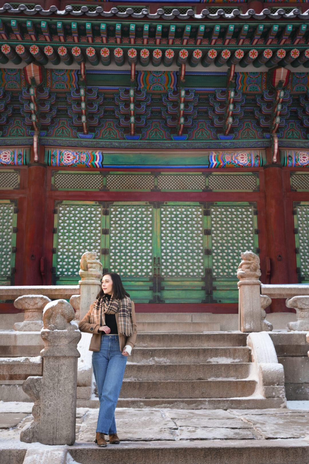Travel Blogger Jordan Gassner looking out from the stairs along the deck around Geunjeongjeon Hall inside Gyeongbokgung Palace in Seoul, South Korea