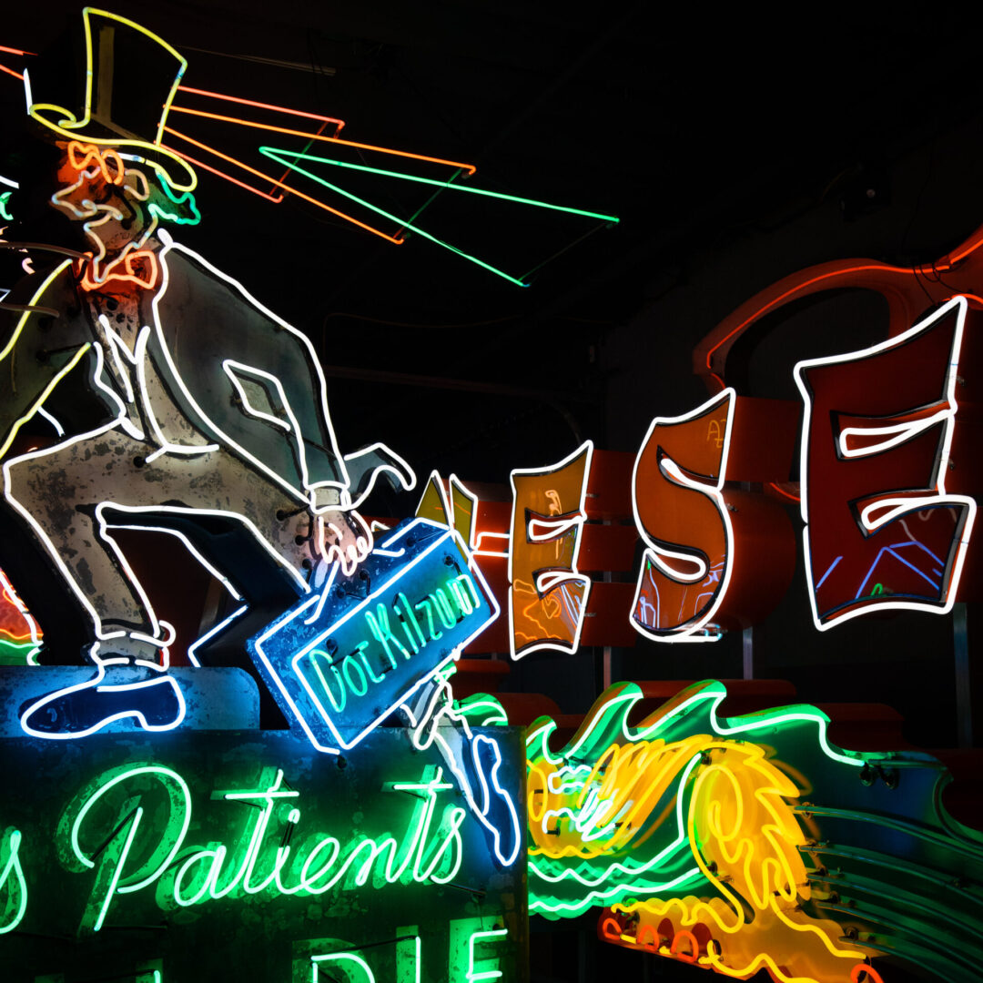 A "His Patients All Die" sign near a "CHINESE" food sign inside the Museum of Neon Art in Glendale, California