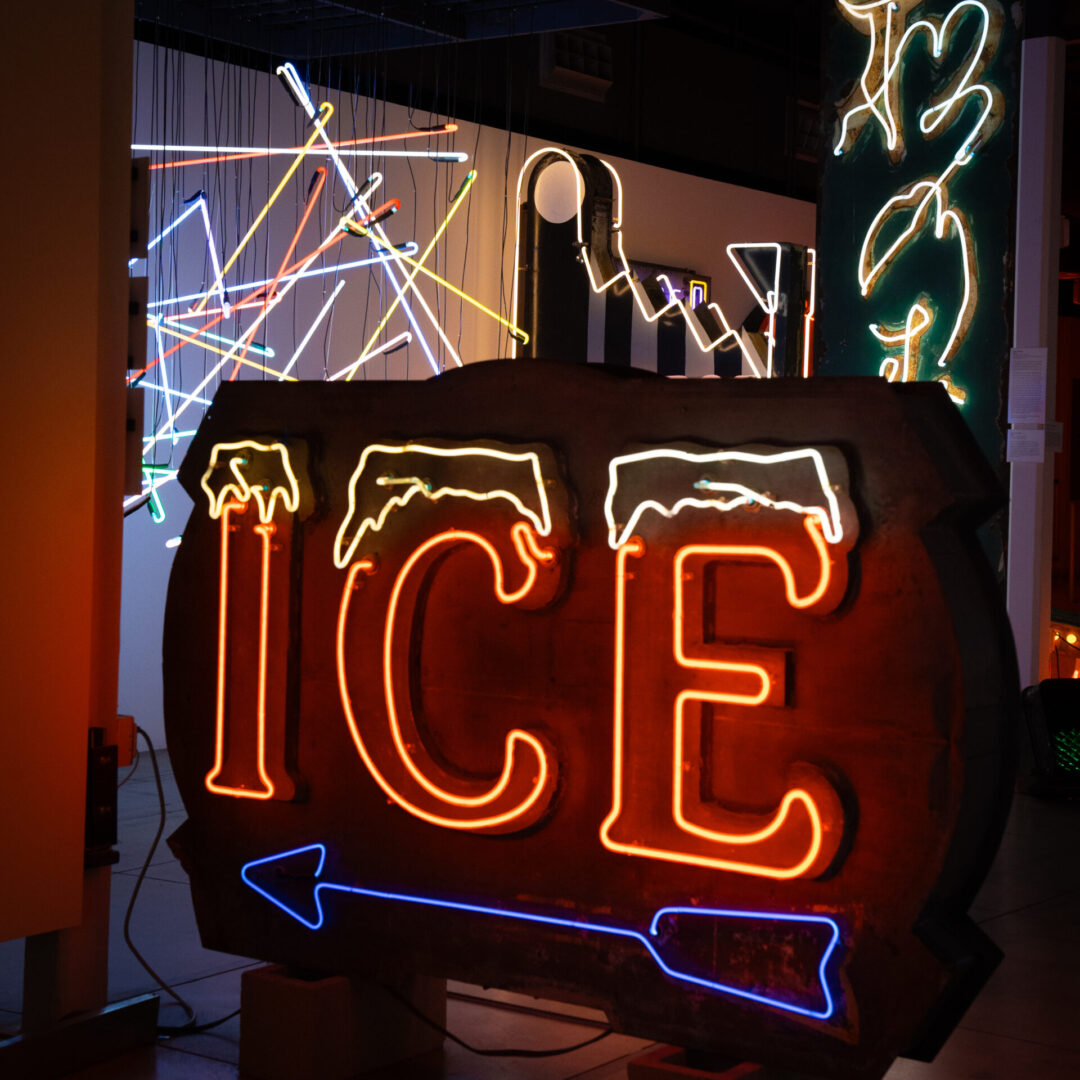 A neon "ICE" sign with a blue arrow inside the Museum of Neon Art in Glendale, California