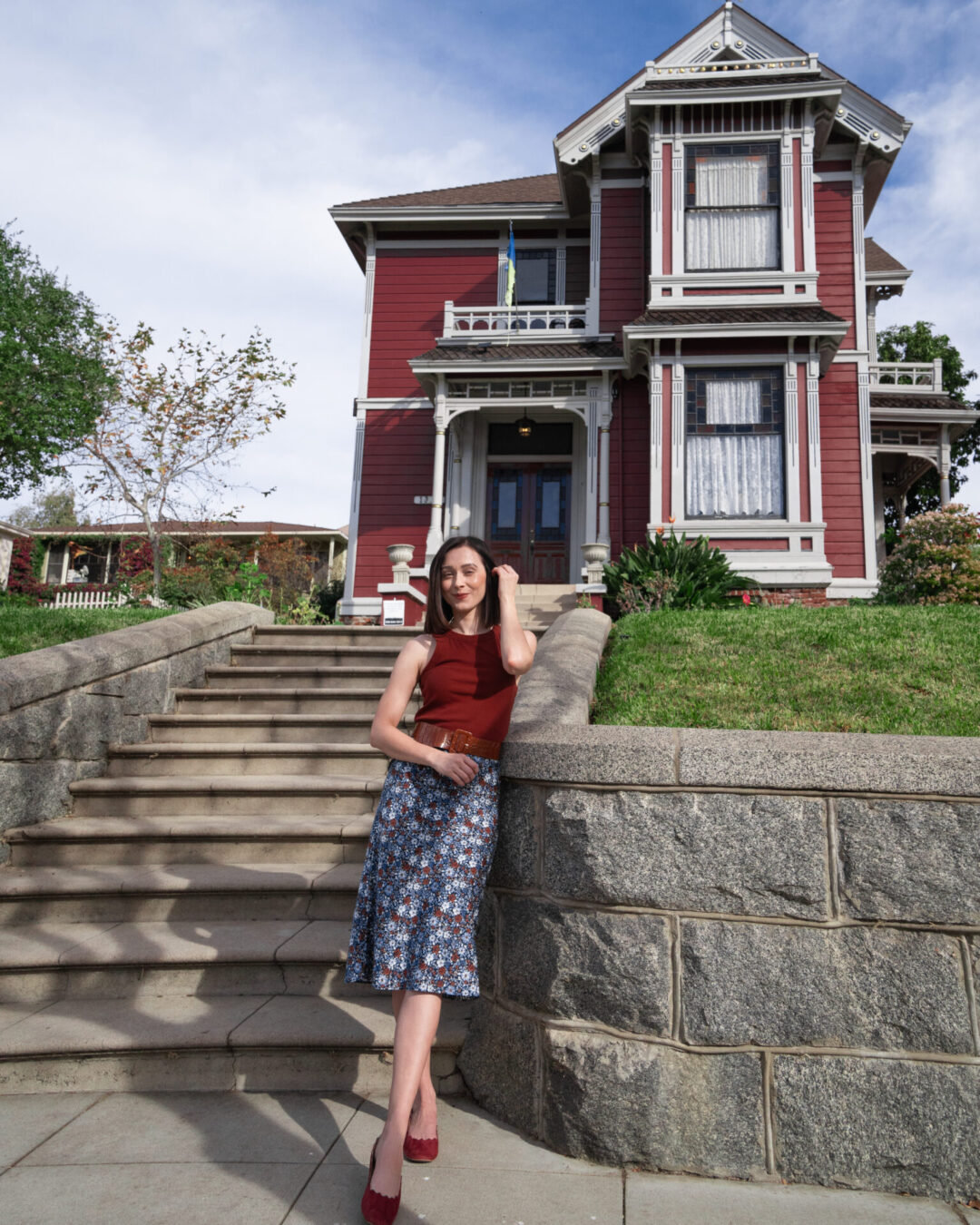 Travel Blogger Jordan Gassner standing in front of the pink-red Charmed TV Show House in the Echo Park neighborhood of Los Angeles, California