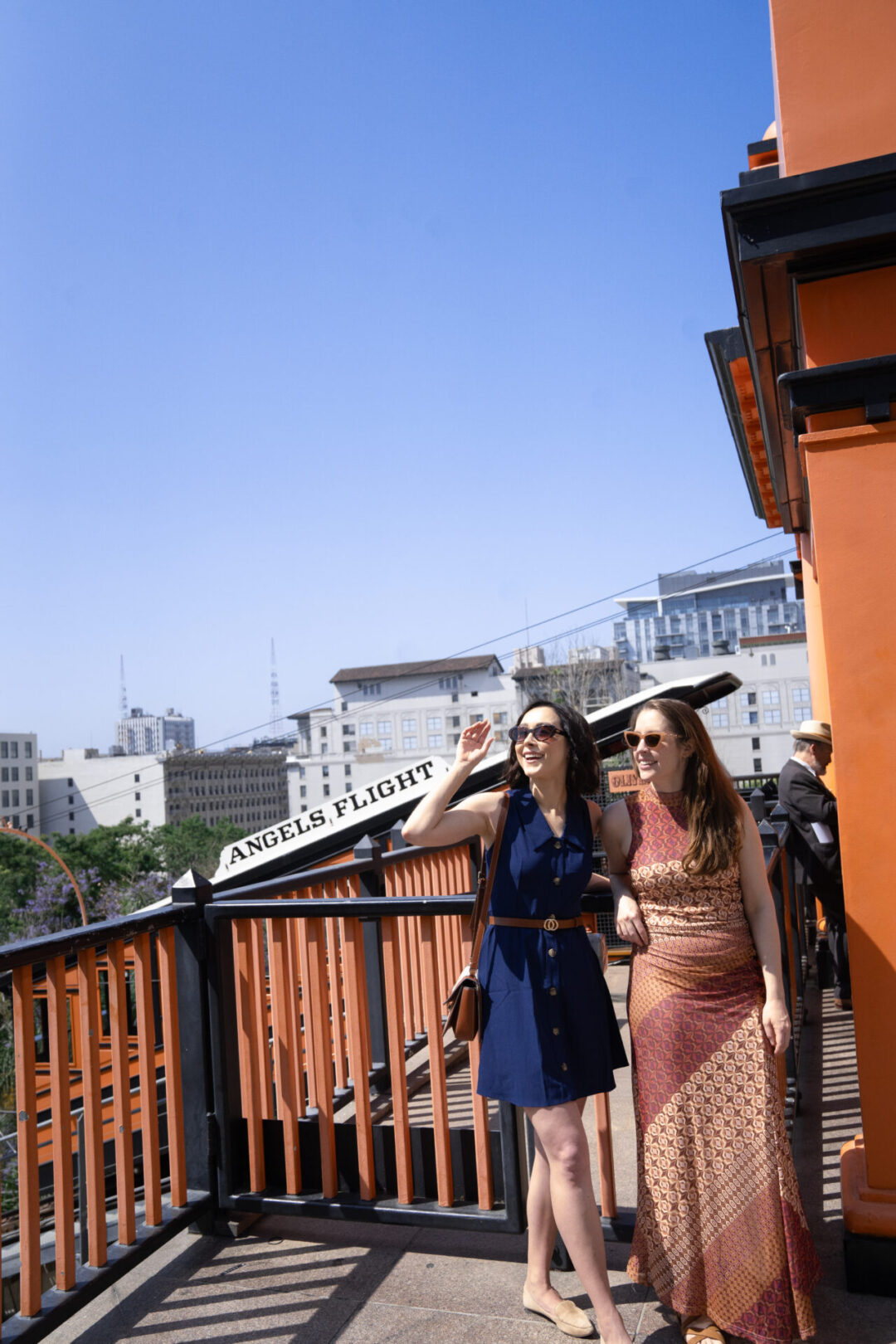 Travel Blogger Jordan Gassner and her friend looking out over Los Angeles and smiling from the top of Angels Flight, a La La Land filming location in Los Angeles, California, USA