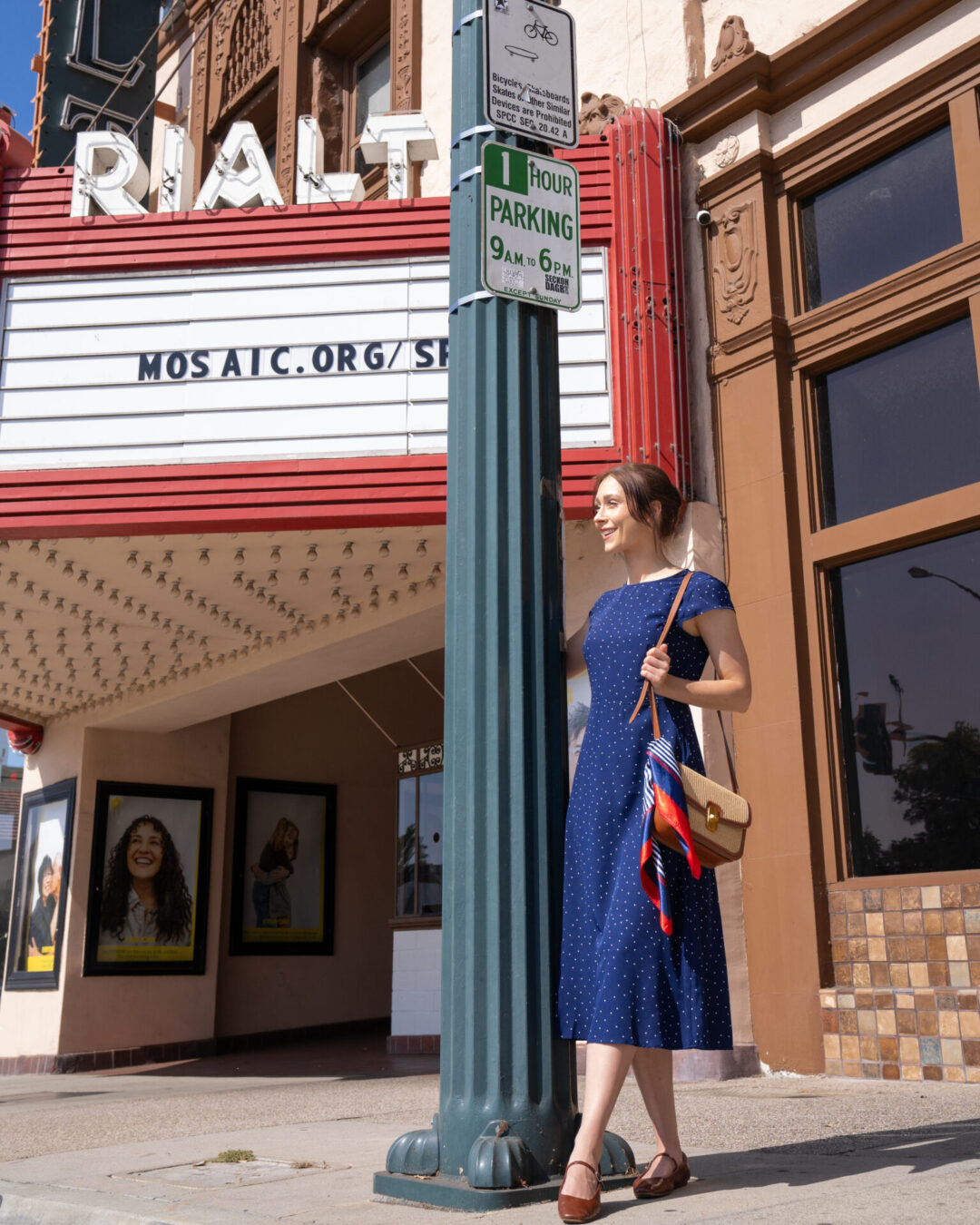 La La Land Travel Guide: Travel Blogger Jordan Gassner leaning against a vintage light post in front of the vintage Rialto Theatre sign in South Pasadena, California