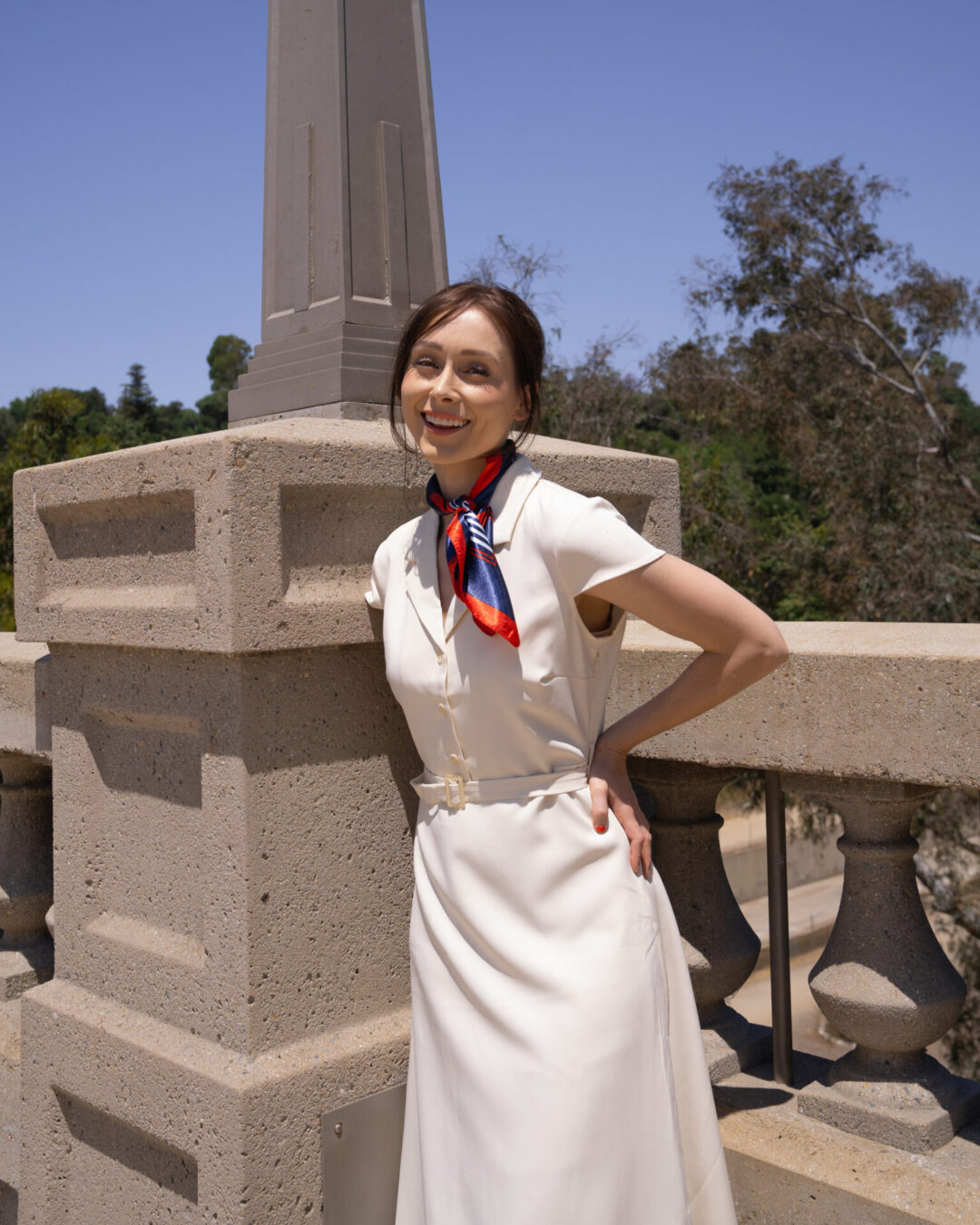 La La Land Travel Guide: Travel Blogger Jordan Gassner smiling under vintage lamppost on La Loma Bridge in Pasadena, California