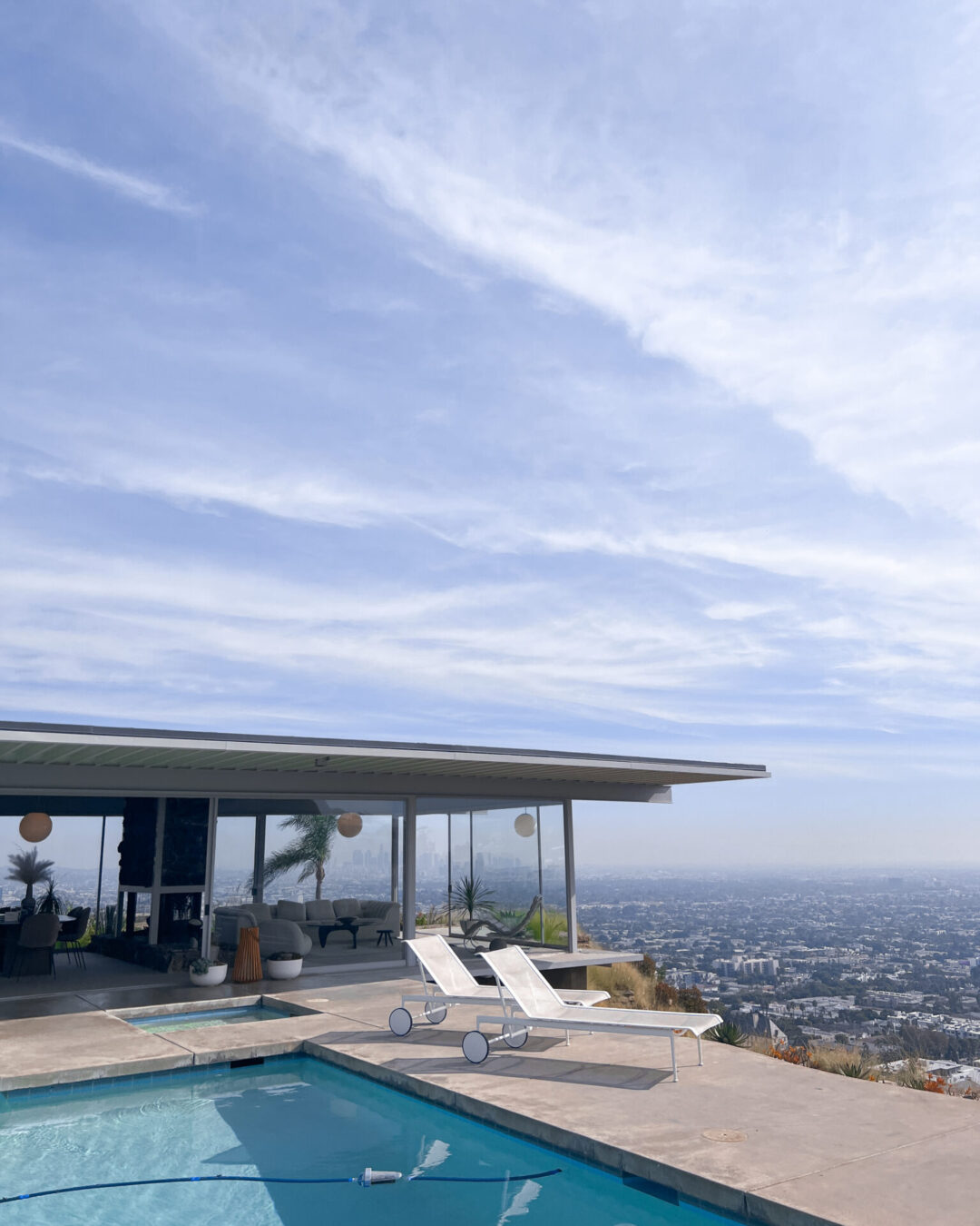 Views over Los Angeles behind the pool and sun tan loungers at the Stahl House, in West Hollywood, California