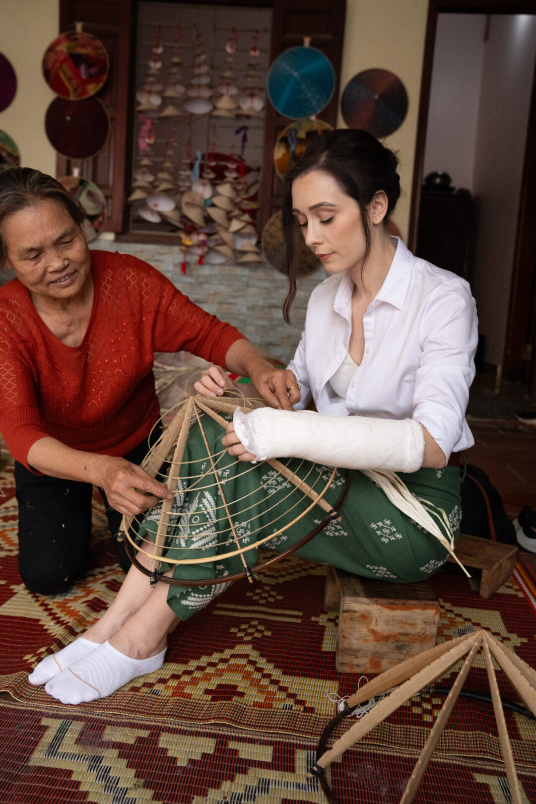 Travel Blogger Jordan Gassner working on a conical hat in the village of Quang Phu Cau near Hanoi, Vietnam