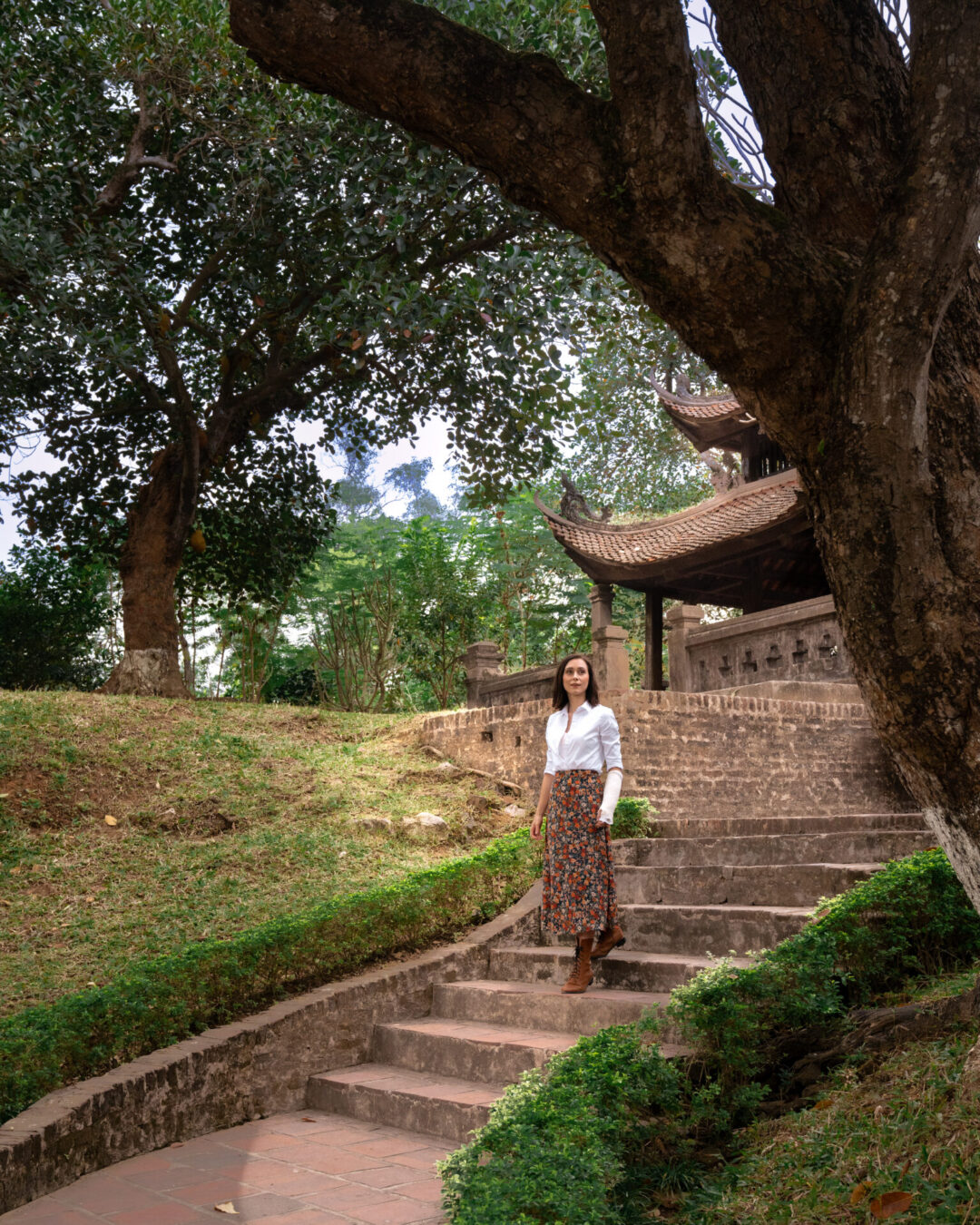 Travel Blogger Jordan GAssner walking down some stairs near a pagoda inside Co Loa Citadel just outside of Hanoi, Vietnam
