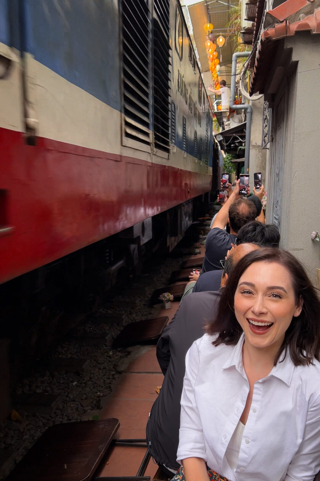 Travel Blogger Jordan Gassner enjoying the thrill of a passing train on Hanoi's Instagram-famous Train Street