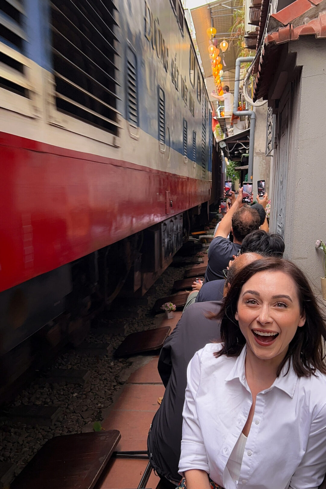 Travel Blogger Jordan Gassner enjoying the thrill of a passing train on Hanoi's Instagram-famous Train Street