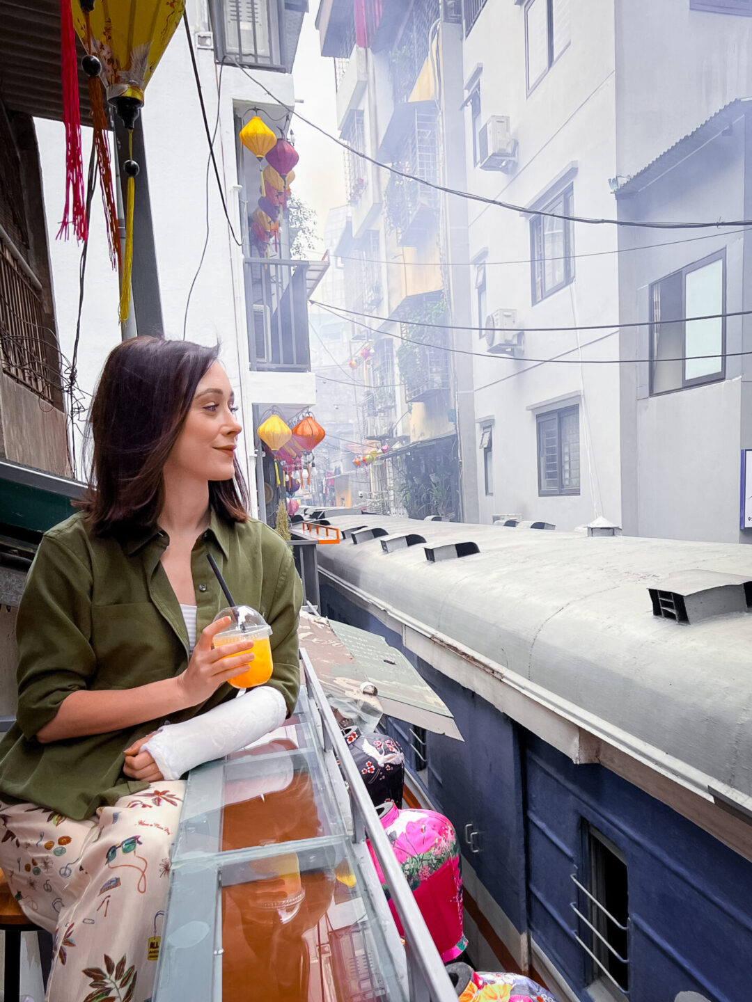 Travel Blogger Jordan Gassner looking at a passing train from a cafe balcony along Train Street in Hanoi, Vietnam