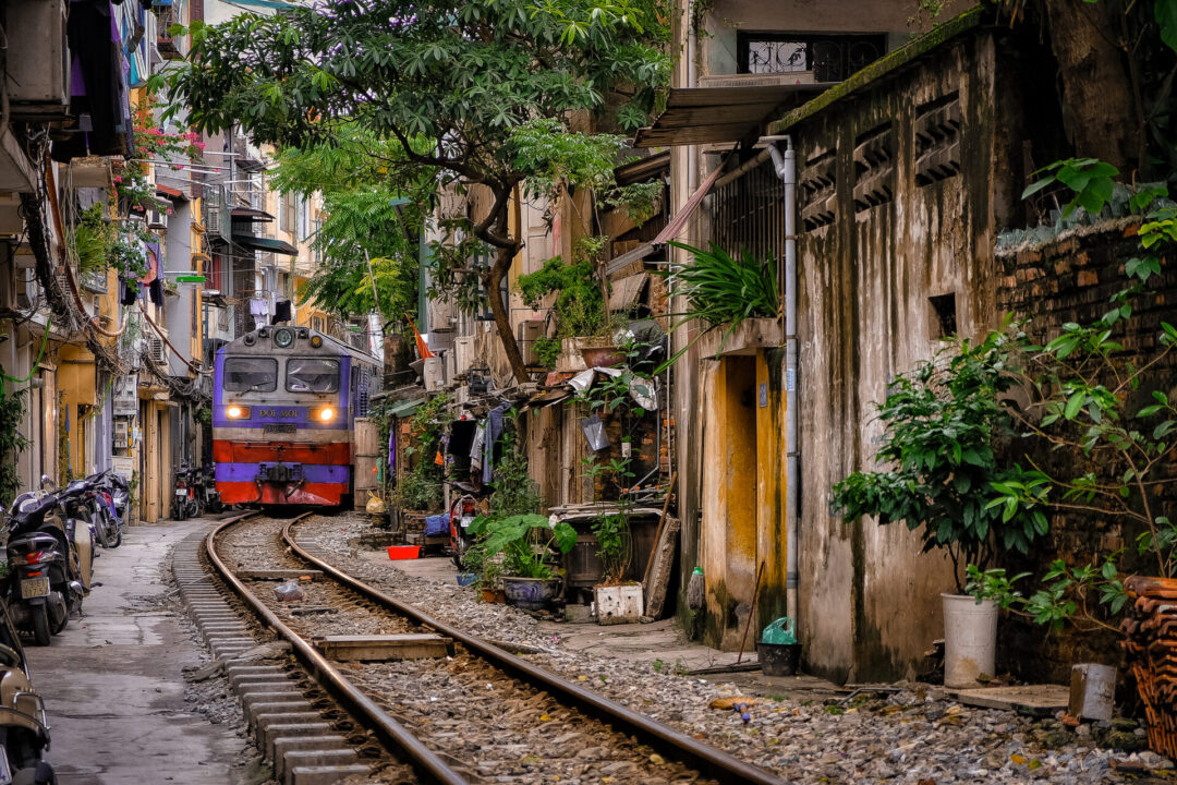 A train passing through the middle of Hanoi, Vietnam with crowded houses on either side
