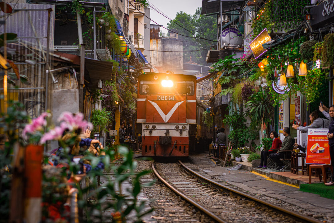 A high speed locomotive train barreling through a residential area known as “Train Street' in Hanoi, Vietnam