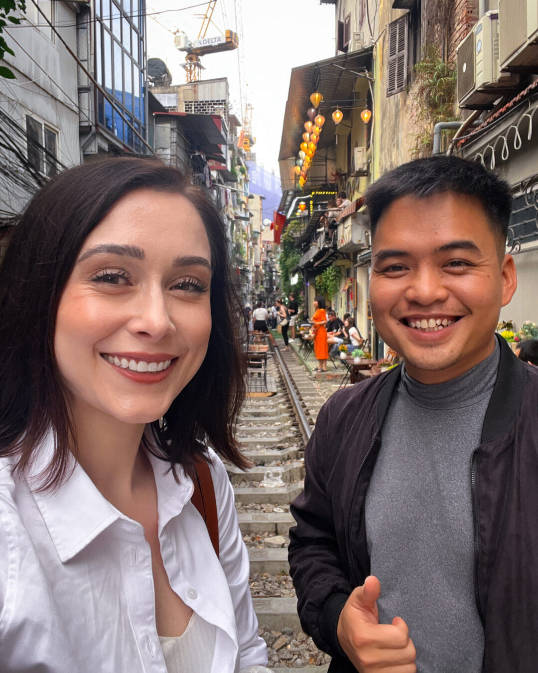 Travel Blogger and her tour guide, Bach, taking a selfie on the train tracks on Train Street in Hanoi, Vietnam