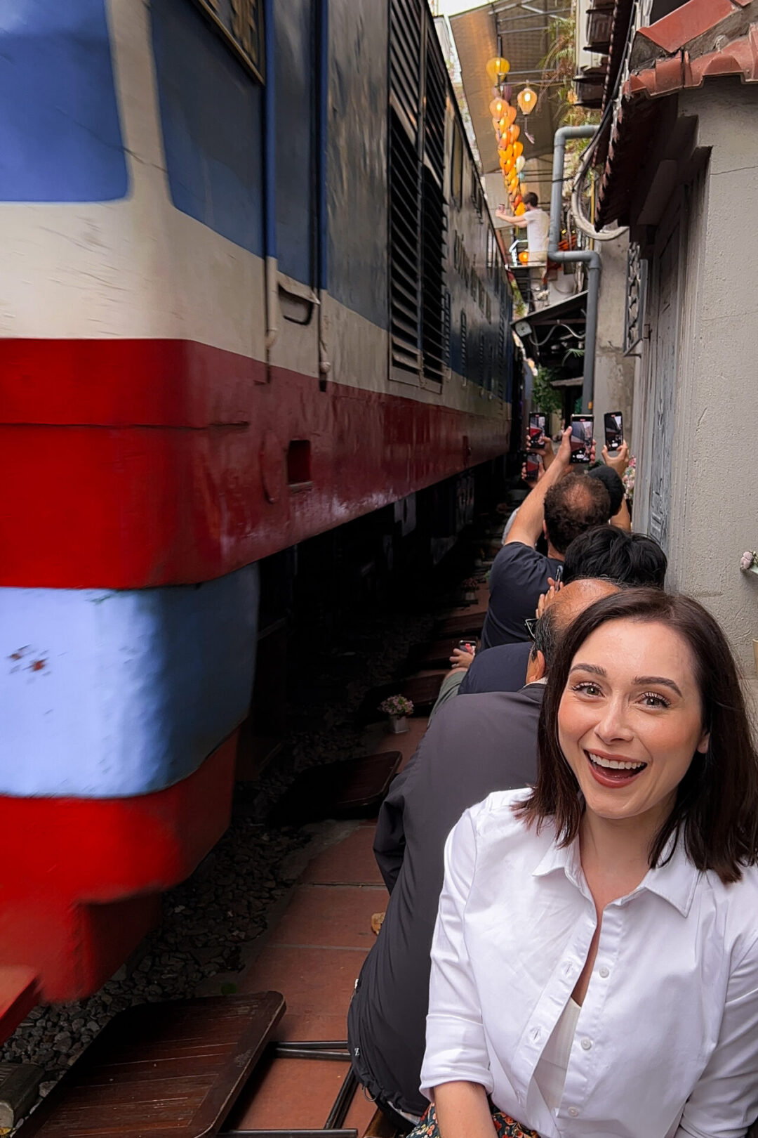 Travel Blogger Jordan Gassner brimming with excitement from an approaching train along Hanoi's Instagram-famous Train Street