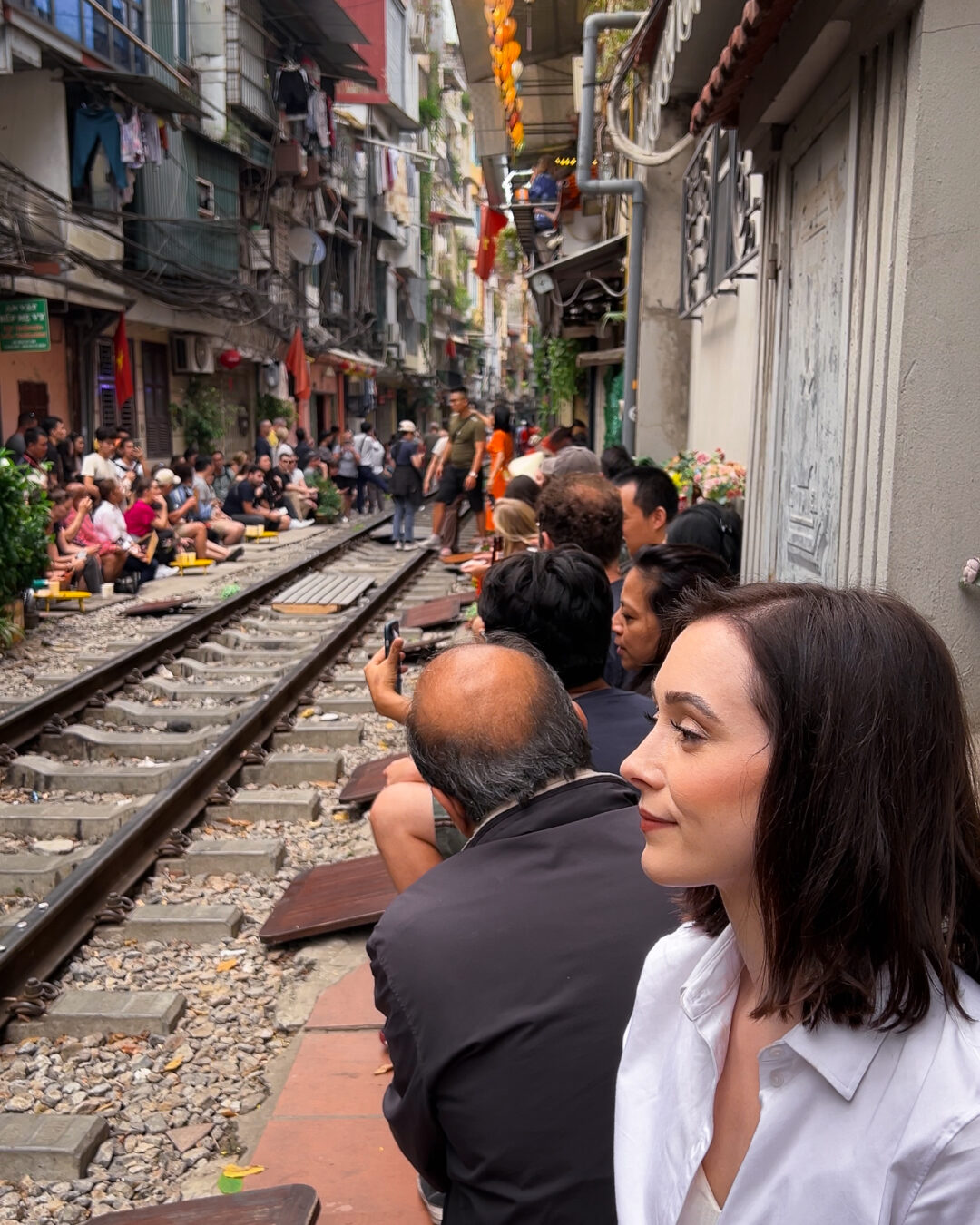 Travel Blogger Jordan Gassner sitting and waiting for an oncoming train at a cafe along Train Street in Hanoi, Vietnam