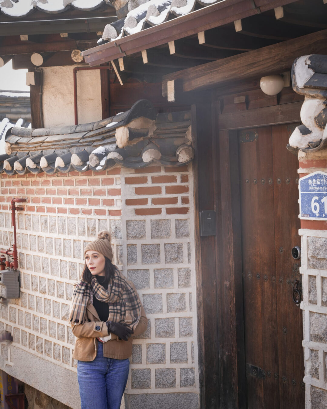 Travel Blogger Jordan Gassner leaning against a wall outside a traditional hanok house in Bukchon Hanok Village in Seoul, South Korea