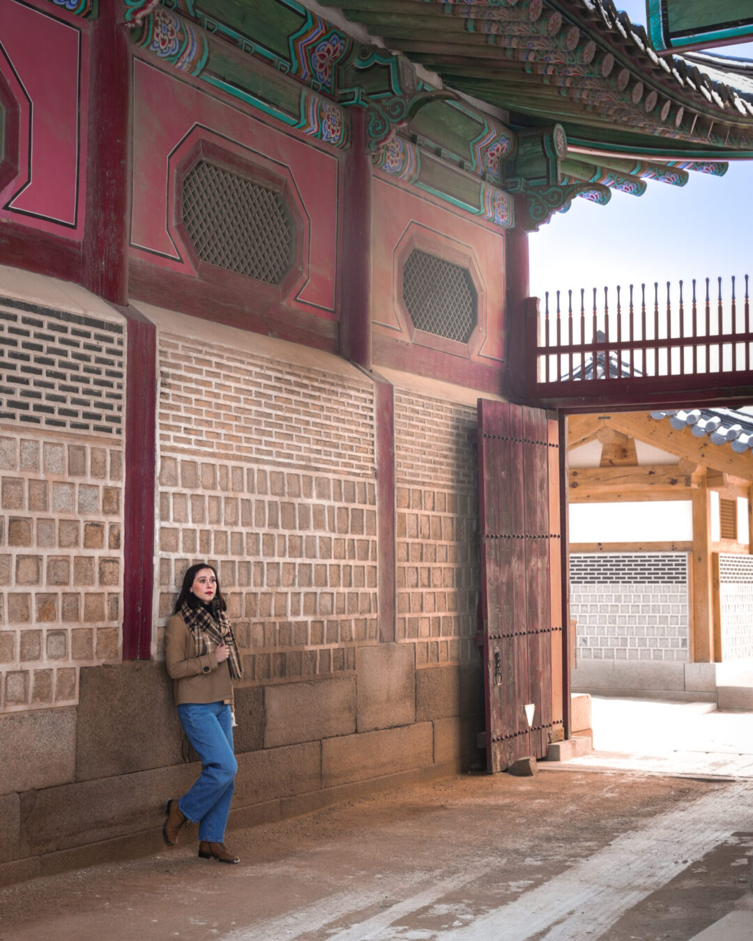 Travel Blogger Jordan Gassner leaning against a large stone building in between Geunjeongjeon Hall and Gyejodang Hall in Seoul, South Korea