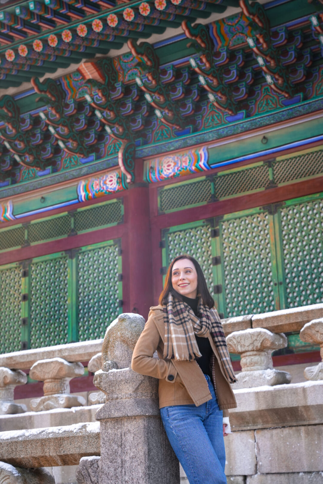Travel Blogger Jordan Gassner smiling while leaning against the stairwell up to Geunjeongjeon Hall inside Gyeongbokgung Palace in Seoul, South Korea