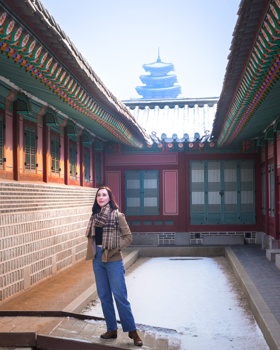 Travel Blogger Jordan Gassner smiling up at the architectural roof details along Jagyeongjeon Hall inside Gyeongbokgung Palace