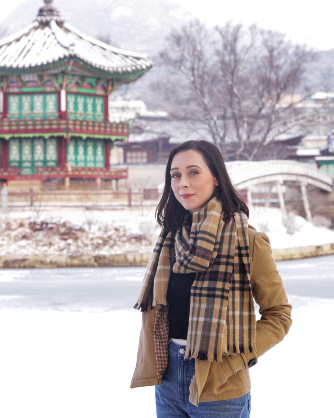 Travel Blogger Jordan Gassner standing in front of a frozen lake at Hyangwonjeong Pavilion inside Gyeongbokgung Palace in Seoul, South Korea