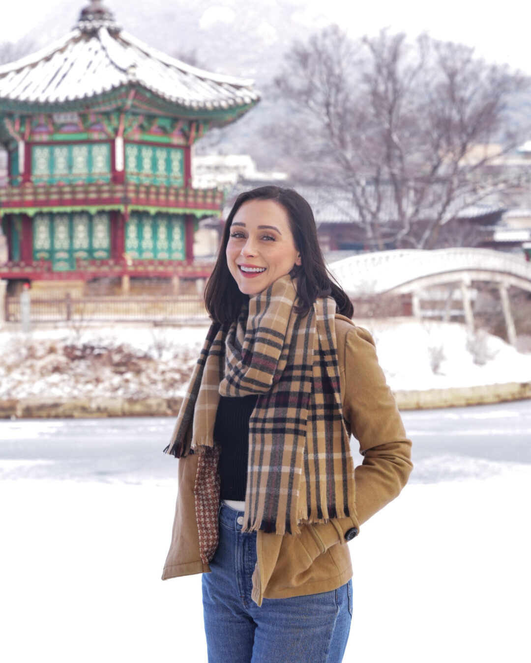Travel Blogger Jordan Gassner smiling in front of a frozen lake at Hyangwonjeong Pavilion inside Gyeongbokgung Palace in Seoul, South Korea