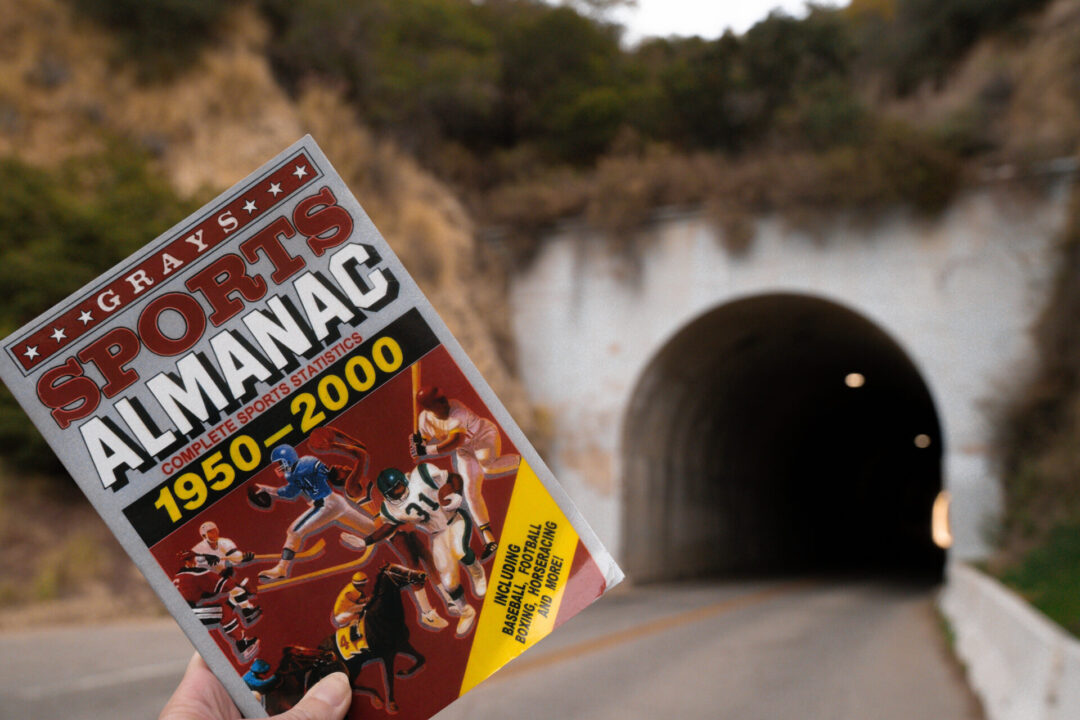 Back To The Future Travel Guide: Travel Blogger Jordan Gassner holding up Grays Sports Almanac near Griffith Park Tunnel, a filming location from the movie