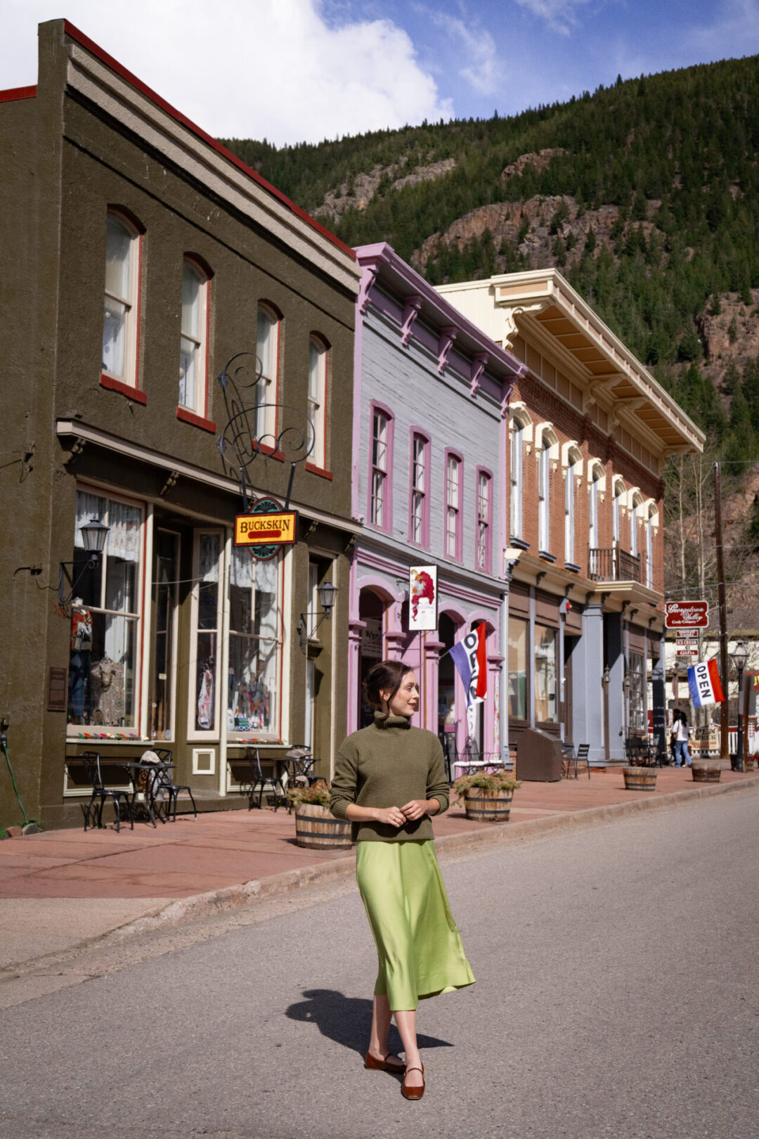Georgetown Colorado Travel: Travel Blogger Jordan Gassner walking along a street with vintage storefronts in Georgetown, Colorado