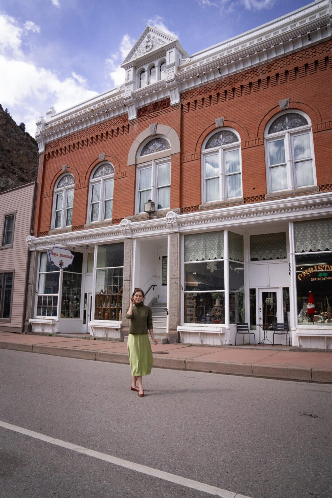 Travel Blogger Jordan Gassner smiling in front of Shoppe International in Georgetown, Colorado