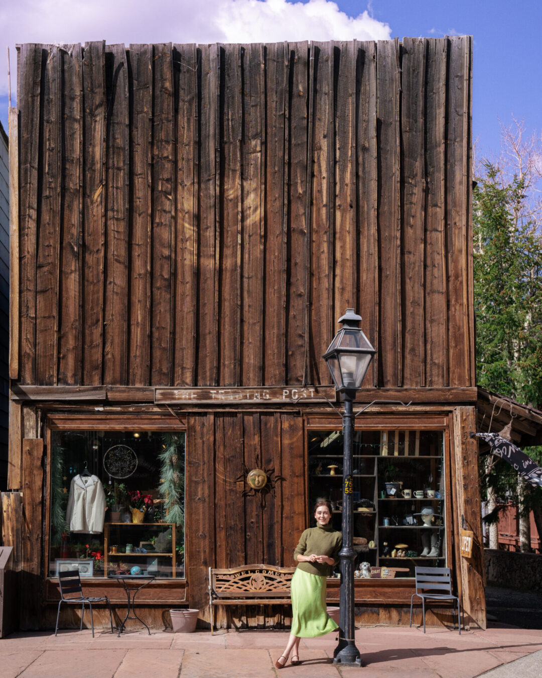 Travel Blogger Jordan Gassner leaning against a lamppost in front of The Trading Post store in Georgetown, Colorado