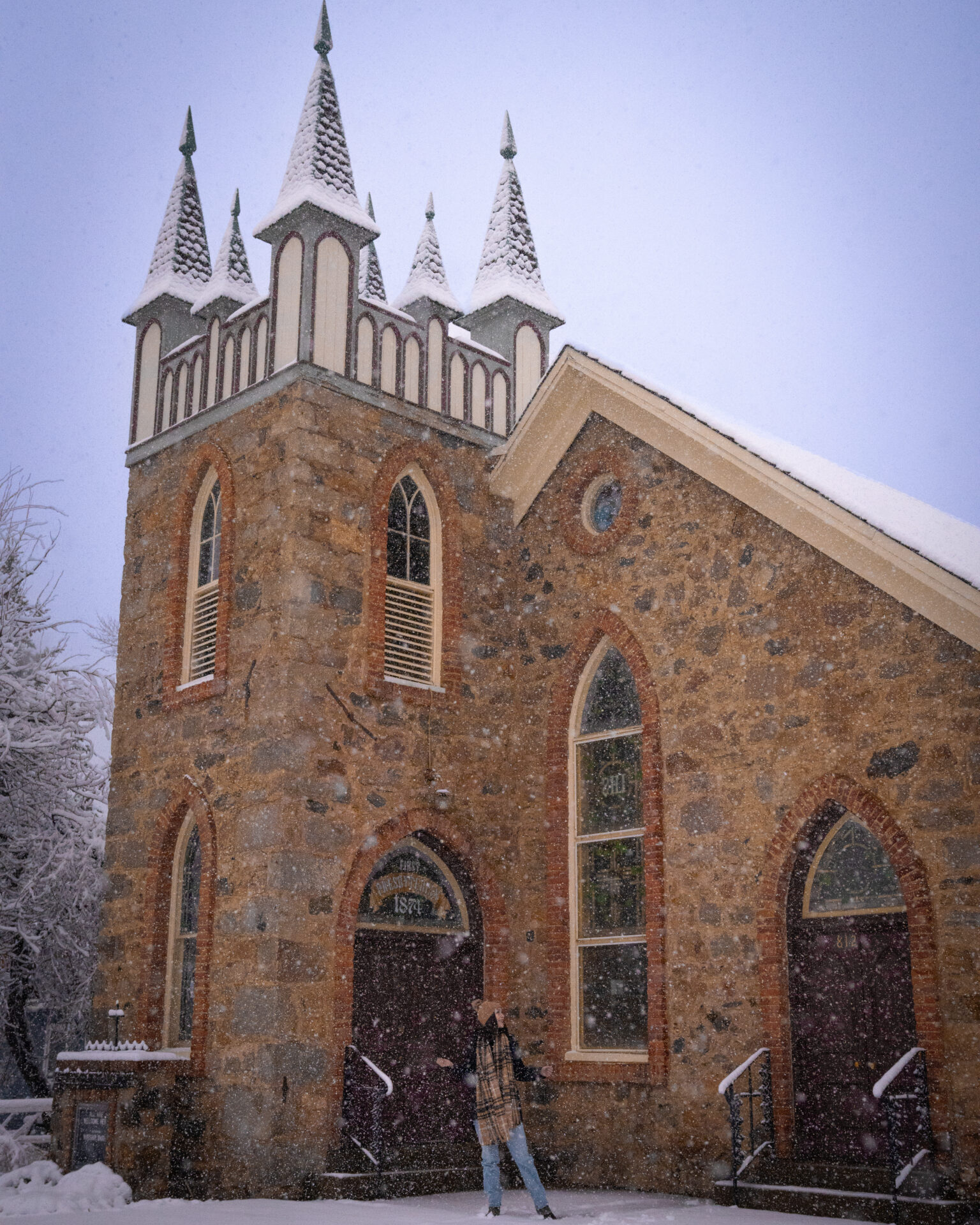 Travel Blogger Jordan Gassner catching snowflakes outside of the First Presbyterian Church of Georgetown in Colorado