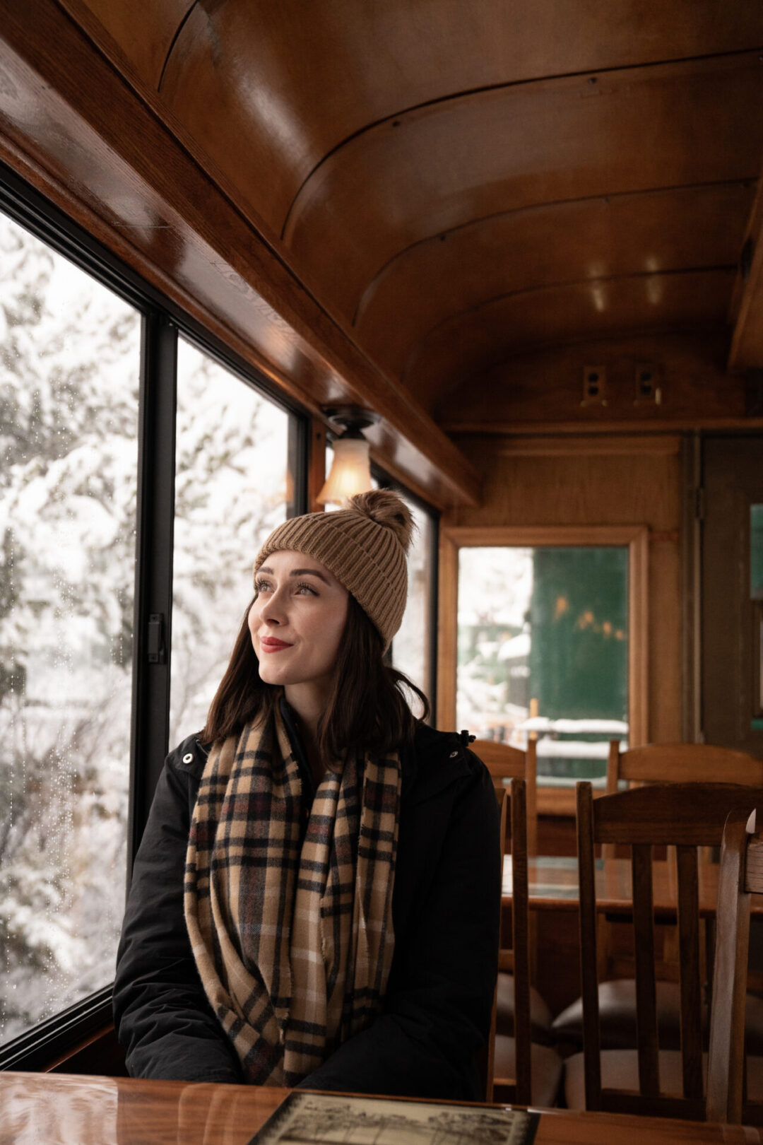 Travel Blogger Jordan Gassner looking out at the snow from the interior of a train car along the Georgetown Loop Railroad in Colorado