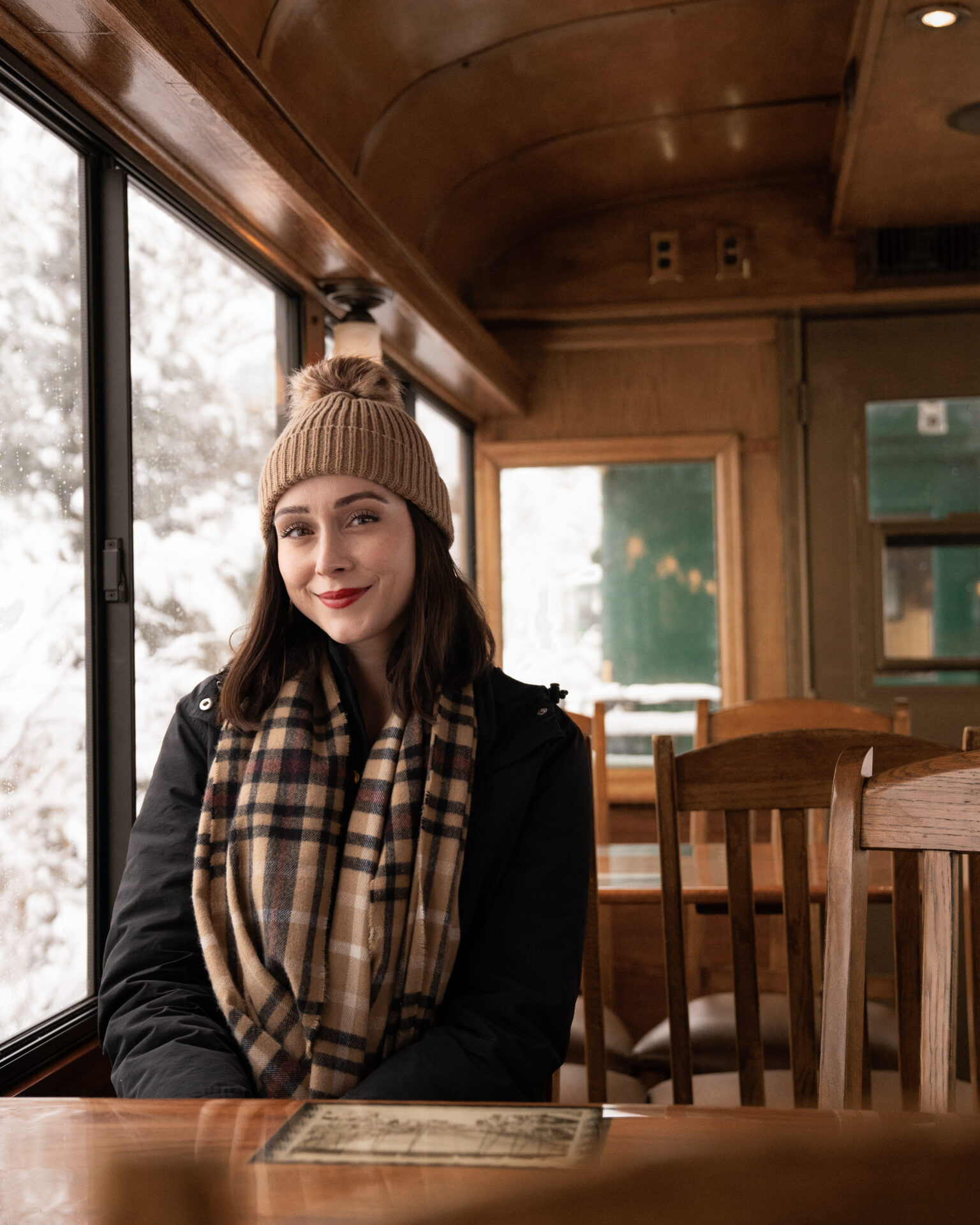 Travel Blogger Jordan Gassner smiling at a table inside Georgetown Loop Railroad in Colorado
