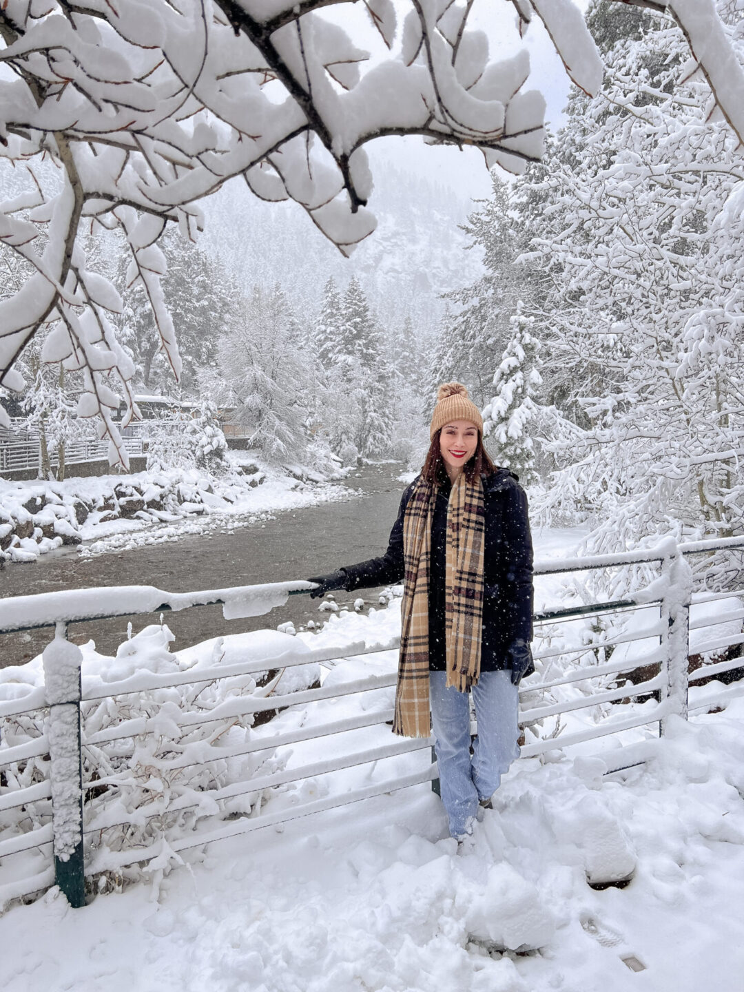 Travel Blogger Jordan Gassner standing near a railing overlooking a river in Georgetown, Colorado