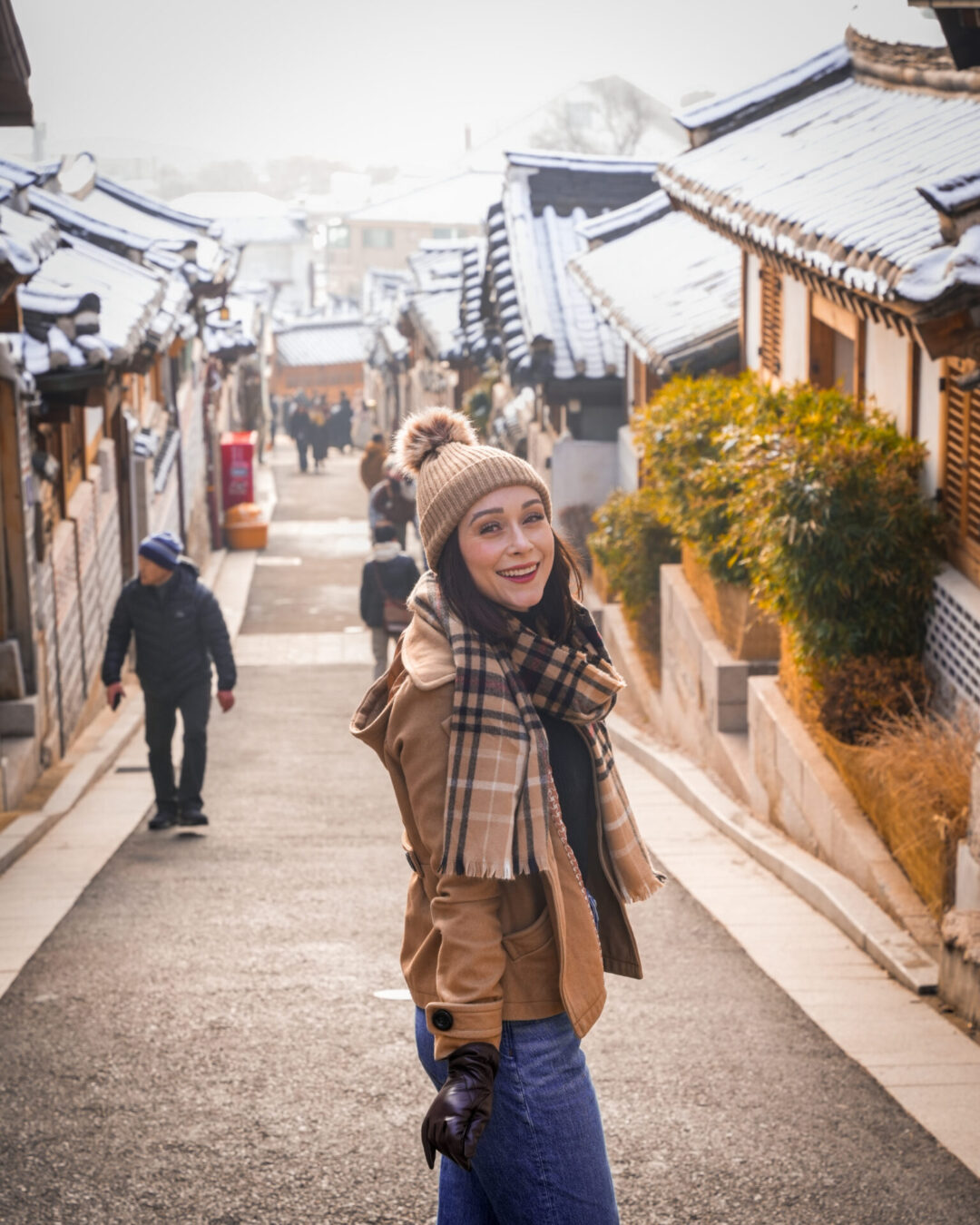 Travel Blogger Jordan Gassner smiling and looking over her shoulder at the top of Bukchon Hanok Village in Seoul, South Korea