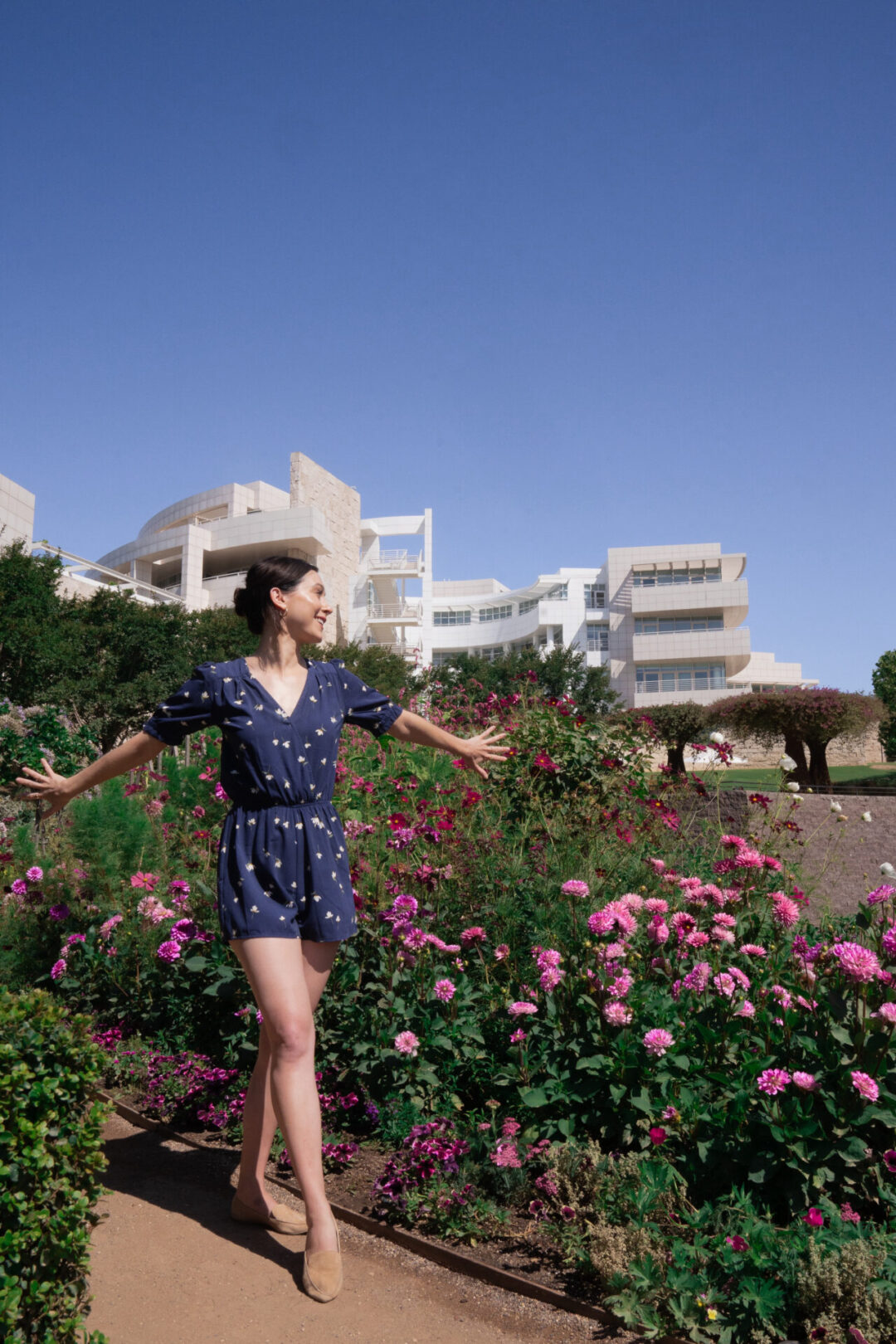 Travel Blogger Jordan Gassner standing with her arms out and smiling at The Getty Center in Los Angeles