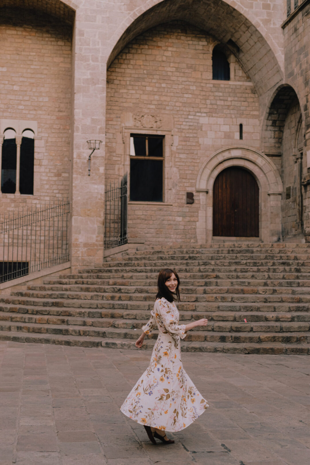 What To Wear In Spain: Travel Blogger Jordan Gassner twirling in a Reformation Dress Barcelona's Old Town